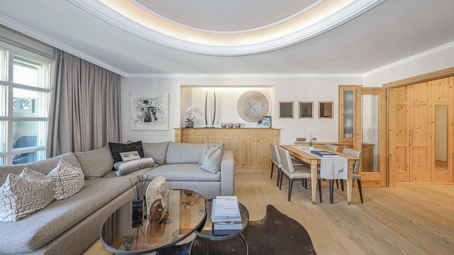 Gemütlicher Wohnbereich mit Sofa, Esstisch und Holzeinbauten, ideal für entspannte Stunden.