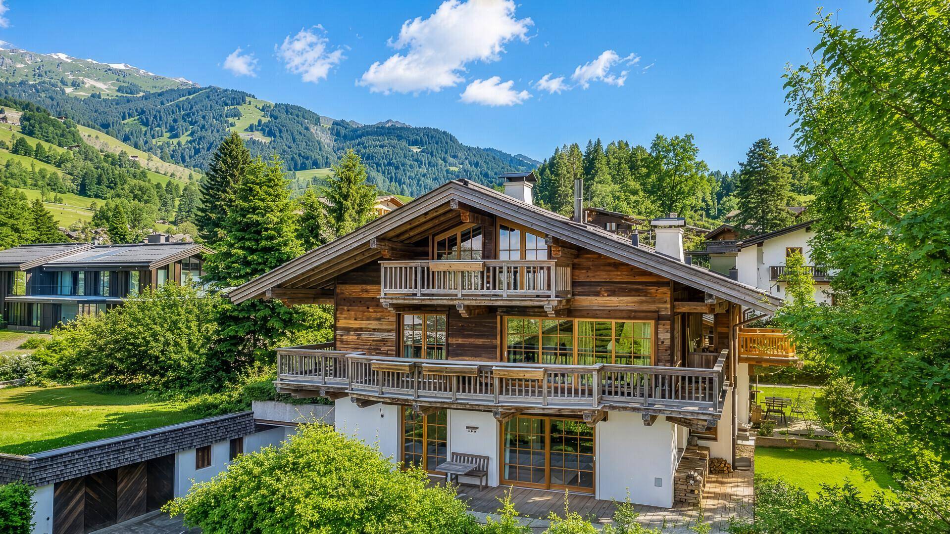 Charmantes Holzhaus im alpinen Stil mit Balkonen und malerischem Bergblick.