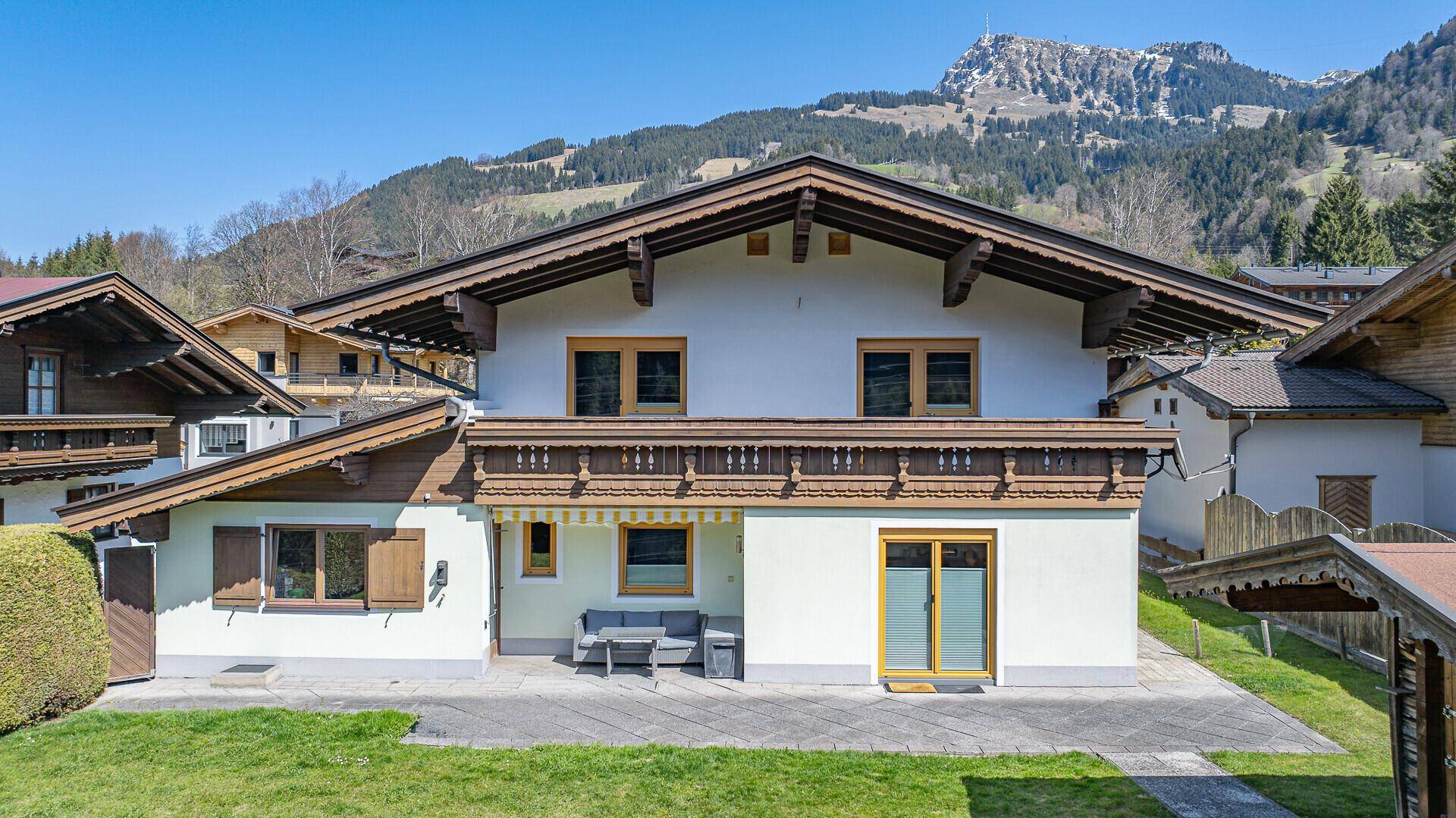 Charmantes Alpenhaus mit traditionellen Holzelementen und einer kleinen Terrasse im Vorgarten.
