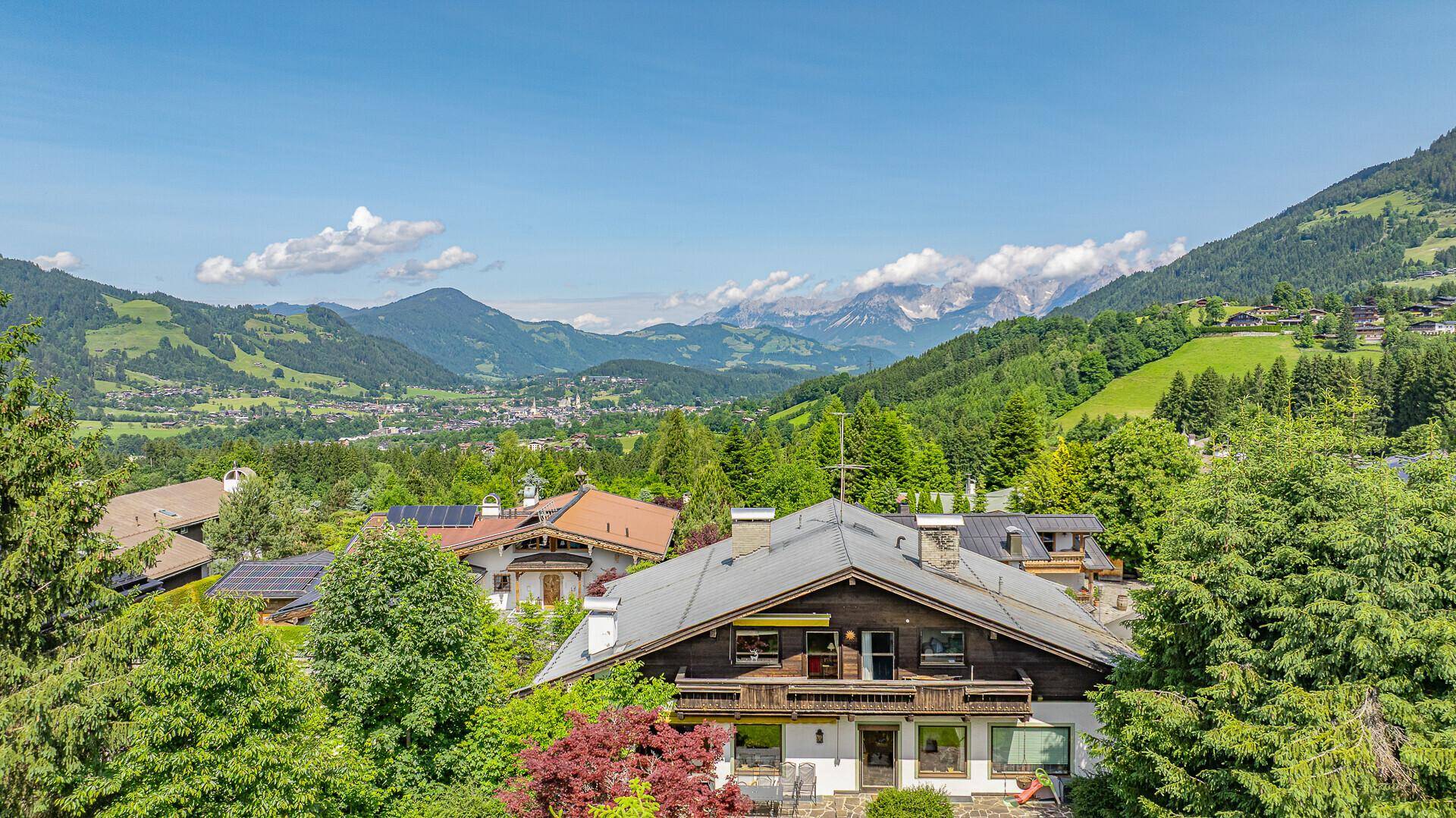 Panoramablick auf das Chalet und die umliegende Berglandschaft mit einem weiten Talblick.