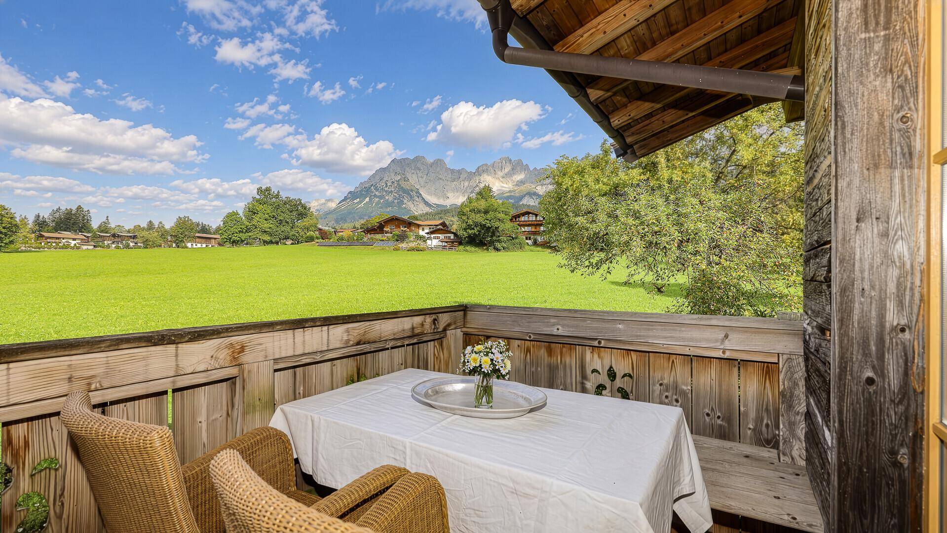 Gemütlicher Balkon mit kleinem Tisch und Stühlen, ideal für ein Frühstück mit Bergblick.