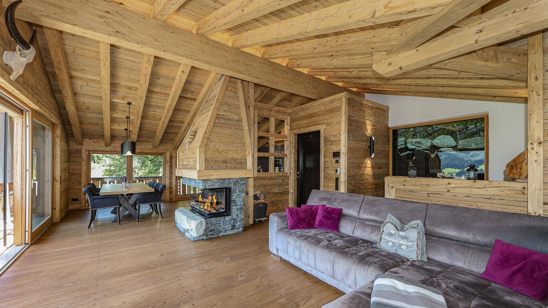Offener Wohn- und Essbereich mit Holzelementen, Kamin und modernem Interieur.
