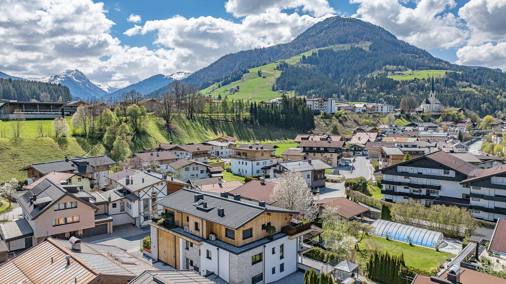 Panoramablick auf ein charmantes Dorf in den Bergen mit vielen Wohnhäusern.