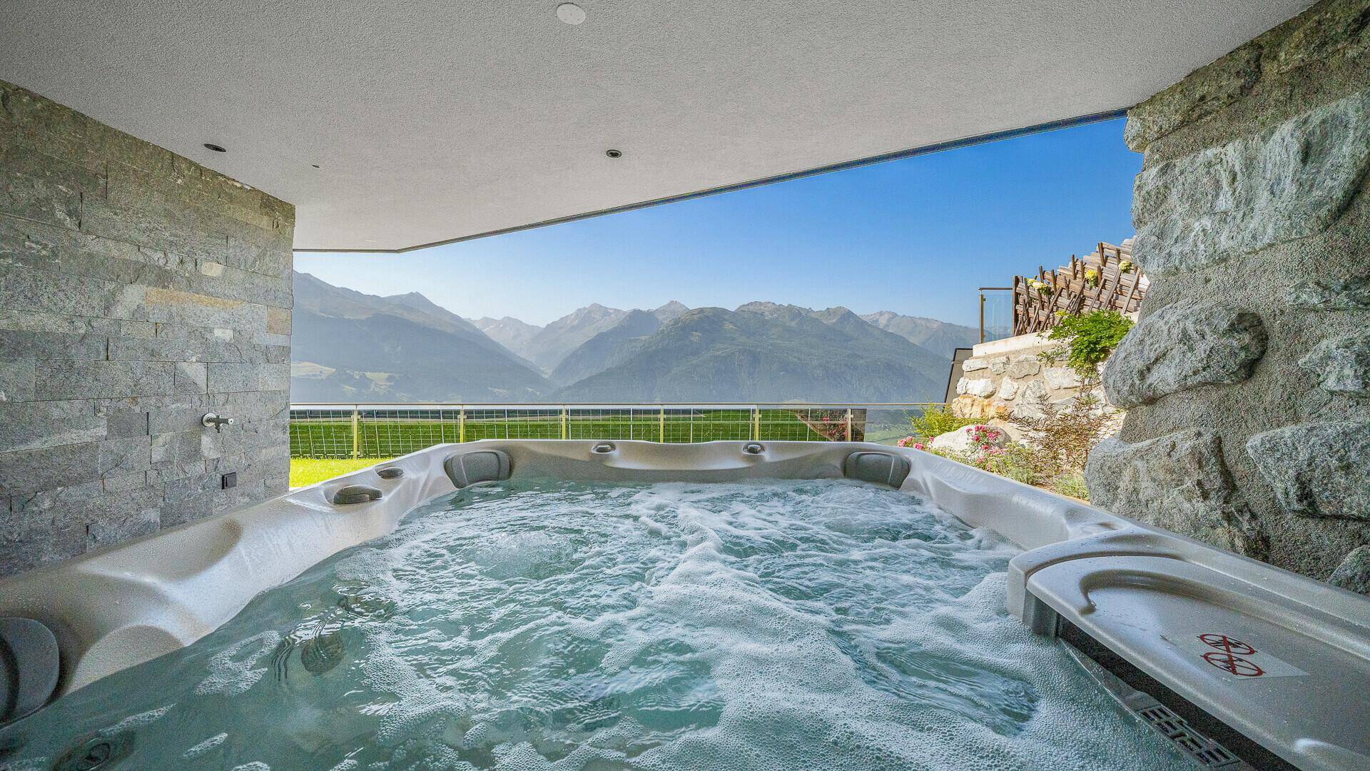 Überdachter Whirlpool mit Bergblick, ideal zur Entspannung im Freien.