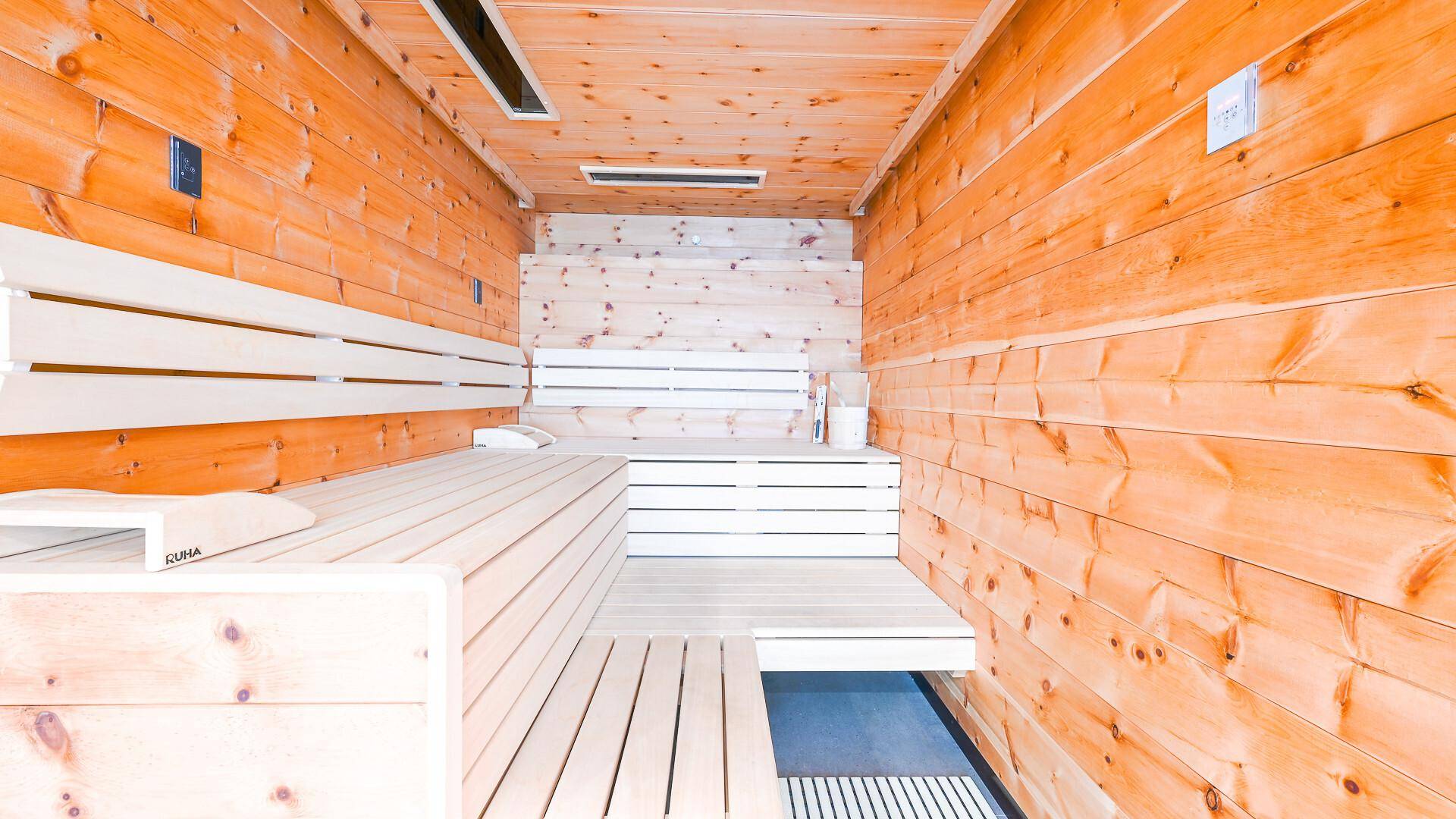 Geräumige Holzsauna mit mehreren Bänken für Entspannung und Wellness.