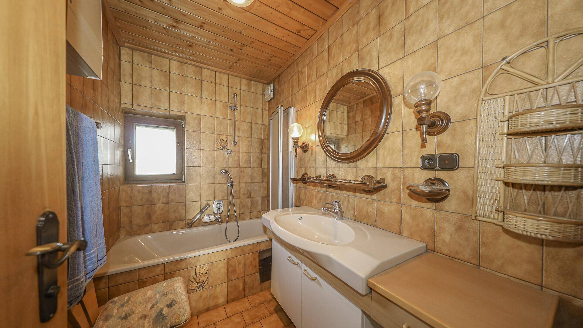 Traditionelles Badezimmer mit Badewanne, Duschfunktion, Einzelwaschbecken und Fenster.