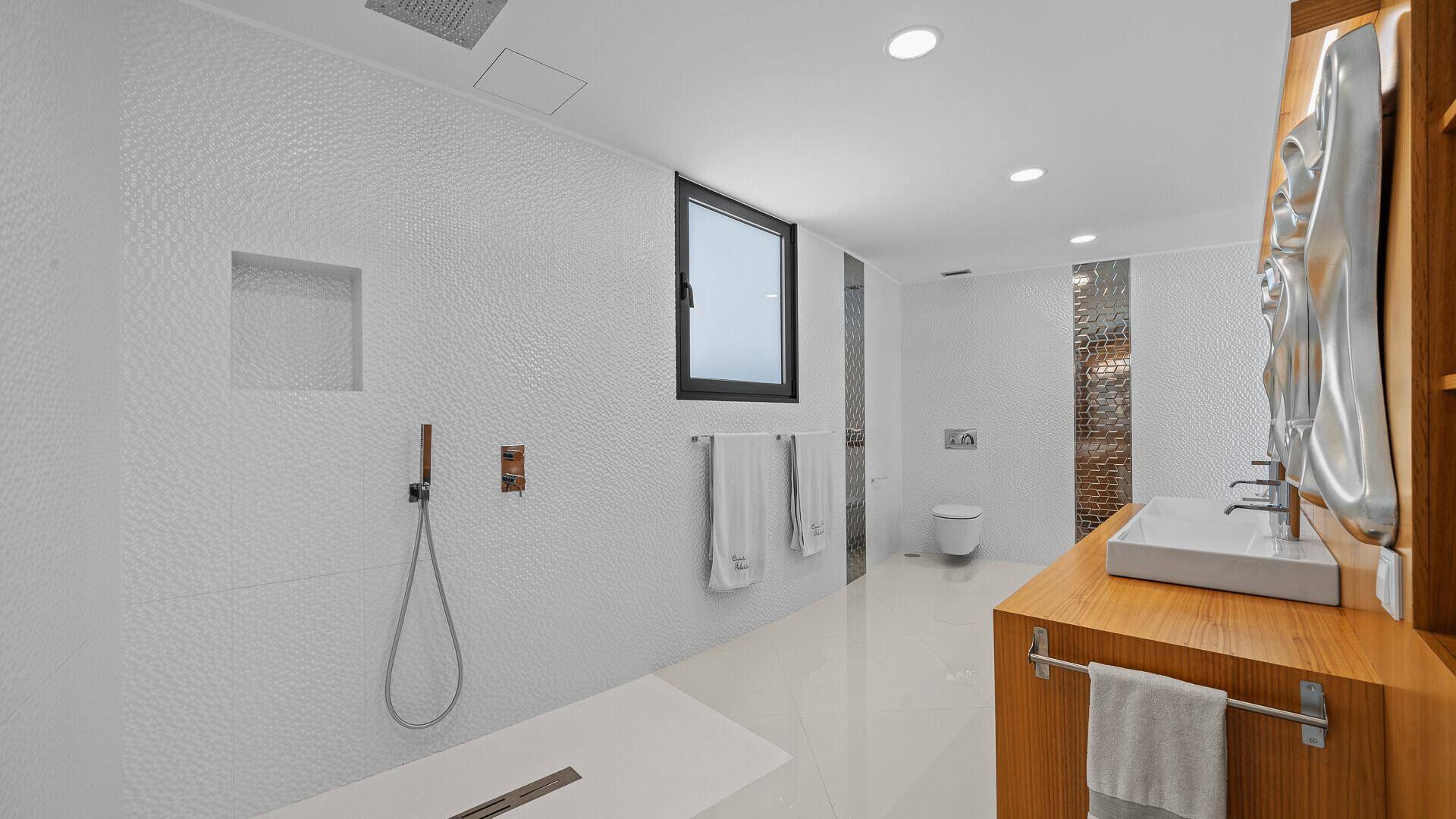 Modernes Badezimmer mit begehbarer Regendusche, Doppelwaschbecken und einem Fenster für Tageslicht.