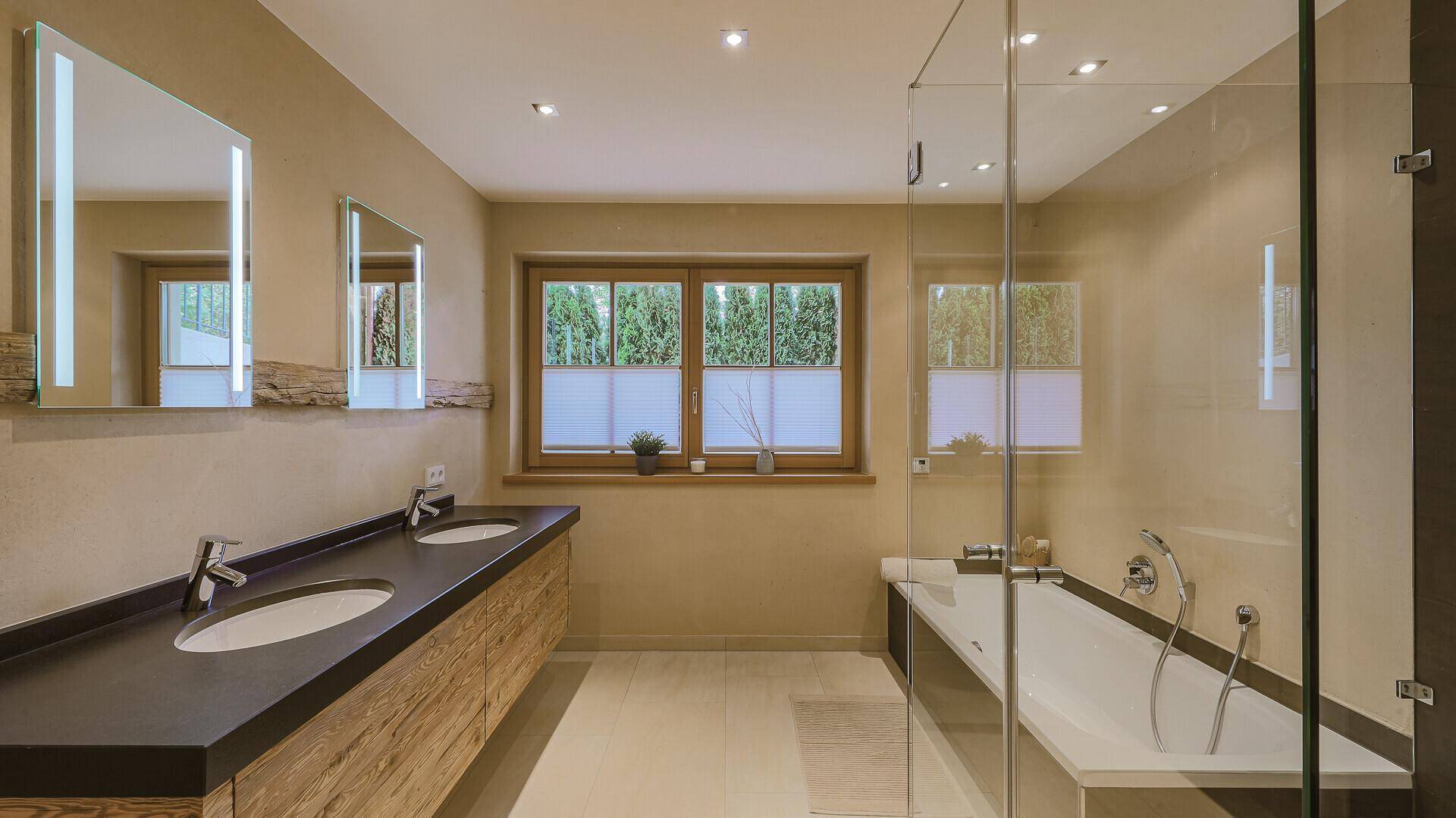 Modernes Badezimmer mit Doppelwaschbecken, Badewanne und begehbarer Dusche sowie Fenster.
