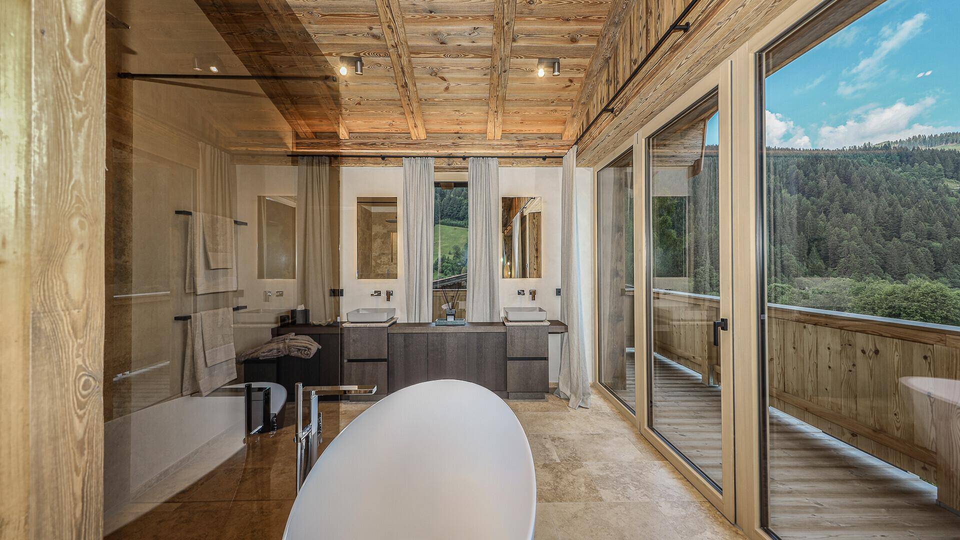 Modernes Badezimmer mit freistehender Badewanne, Doppelwaschbecken und Bergblick.