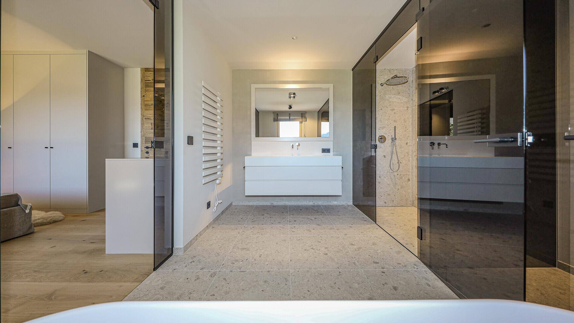 Elegantes Badezimmer mit Doppelwaschbecken, großer Dusche und moderner Ausstattung.