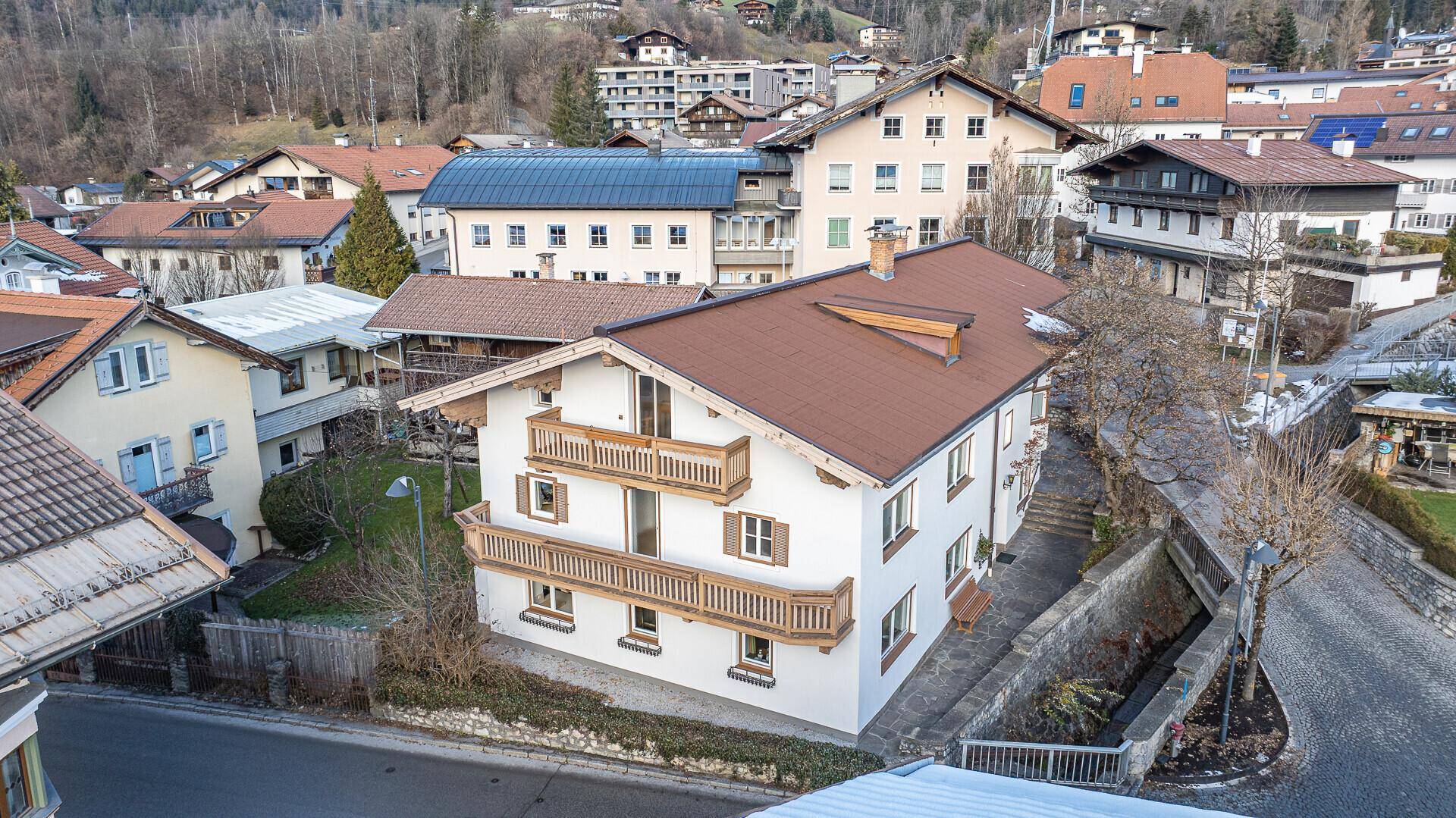 Ansicht des Gebäudes von oben mit braunem Dach und mehreren Balkonen.