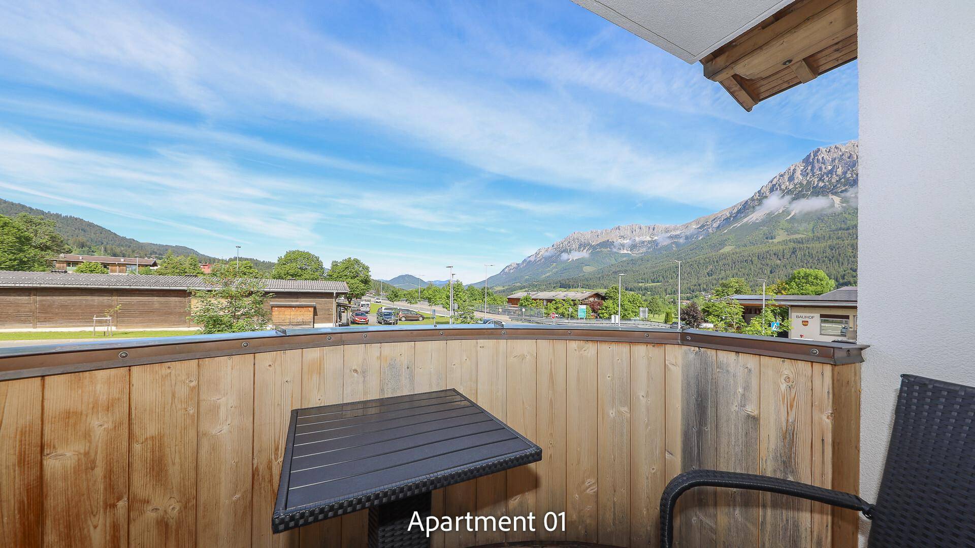 Balkon mit Holzboden, Sitzgelegenheiten und weitem Blick auf die Berge.