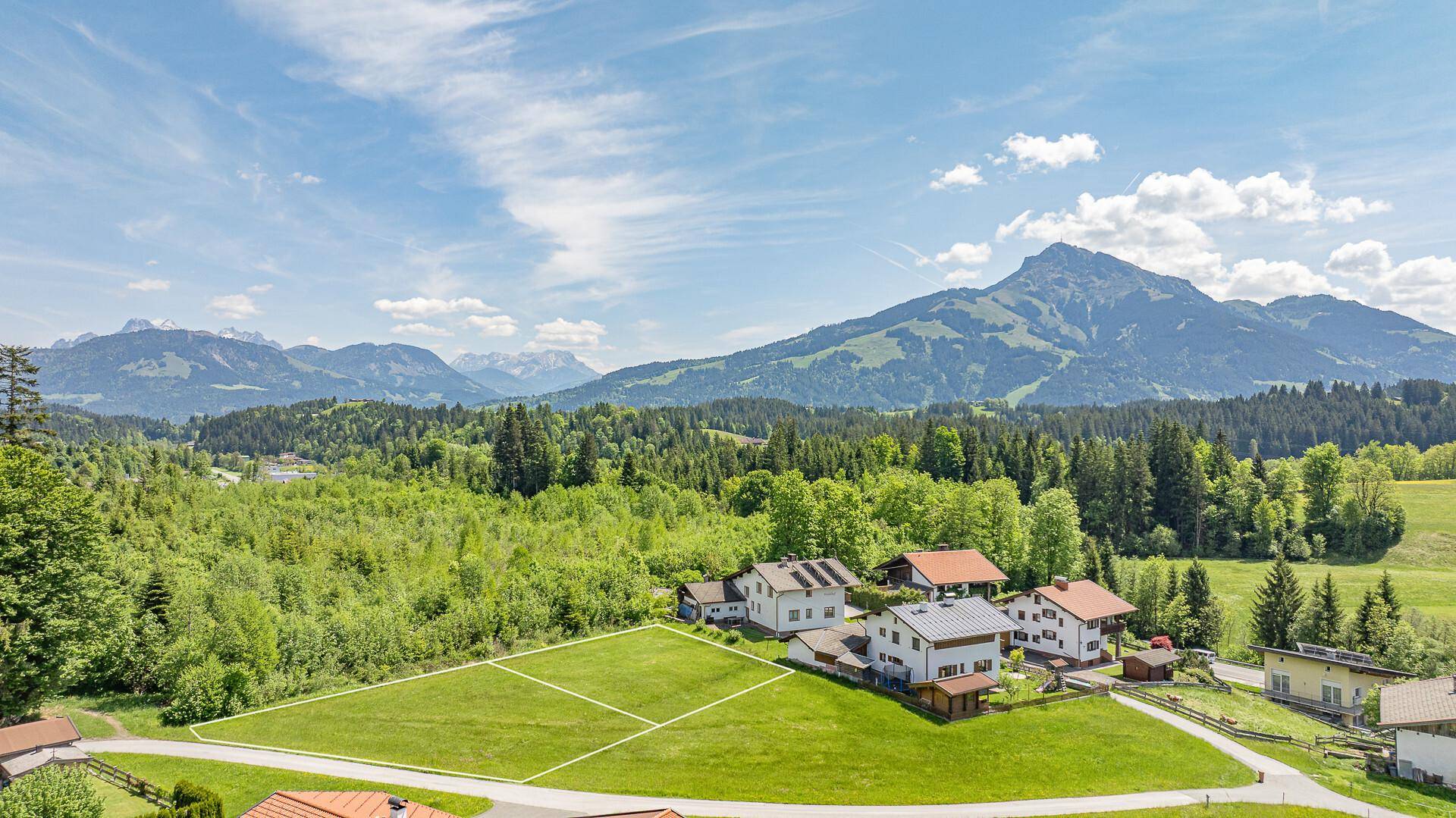 Panoramablick auf die ländliche Umgebung mit mehreren Häusern und einem freien Baugrundstück.