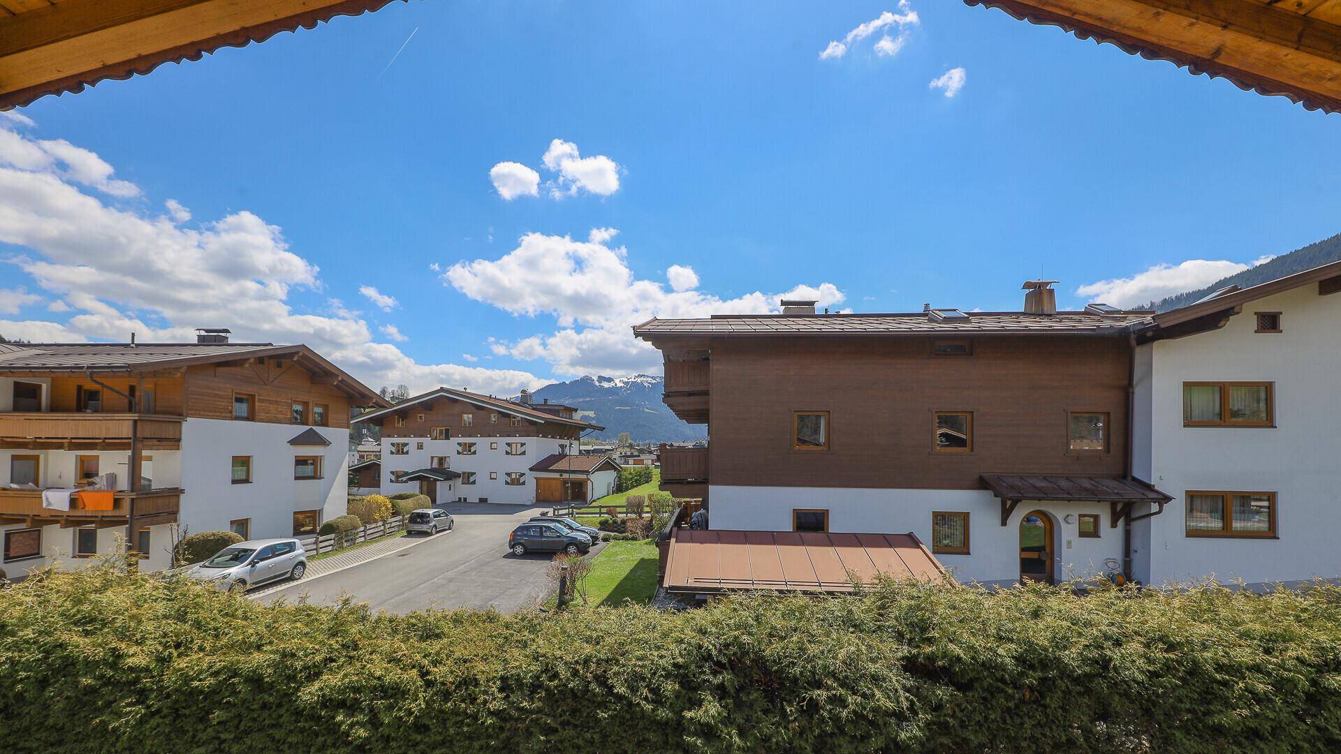 Blick auf die Nachbarschaft mit weiteren Chalets und den Bergen im Hintergrund.