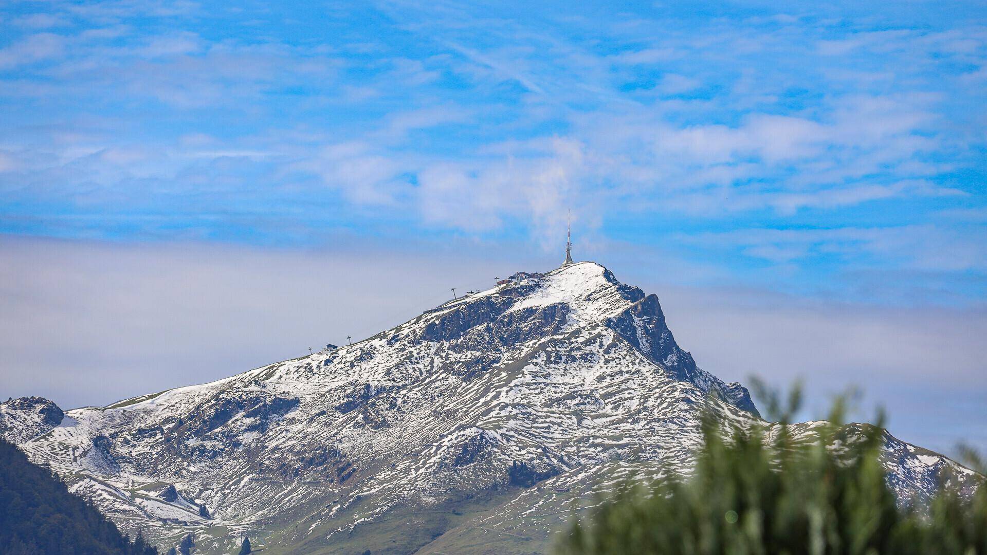 Nahaufnahme eines majestätischen schneebedeckten Berggipfels unter einem klaren blauen Himmel.