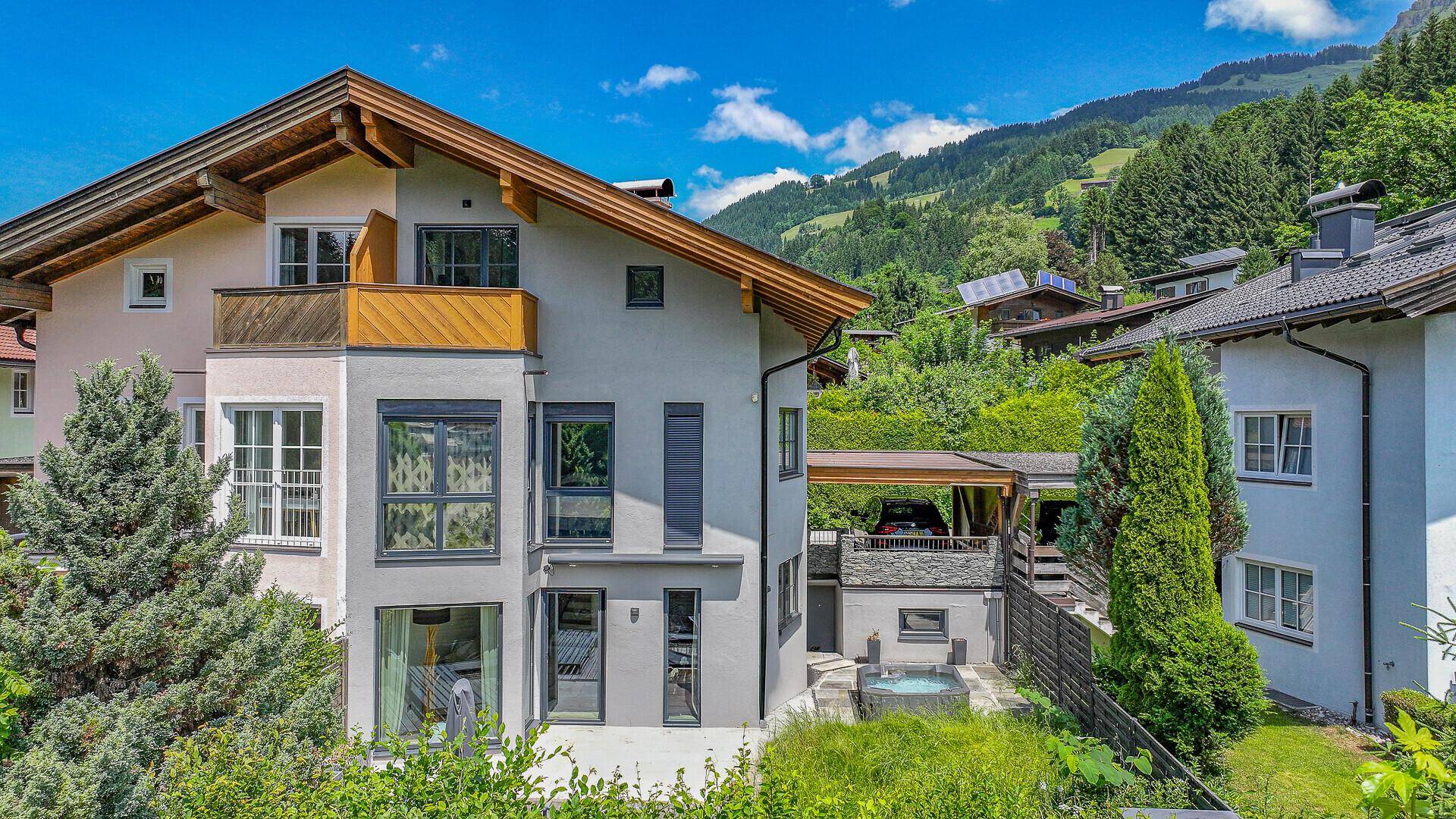Charmantes Haus in alpiner Umgebung mit gepflegtem Garten und Blick auf die grünen Hügel.