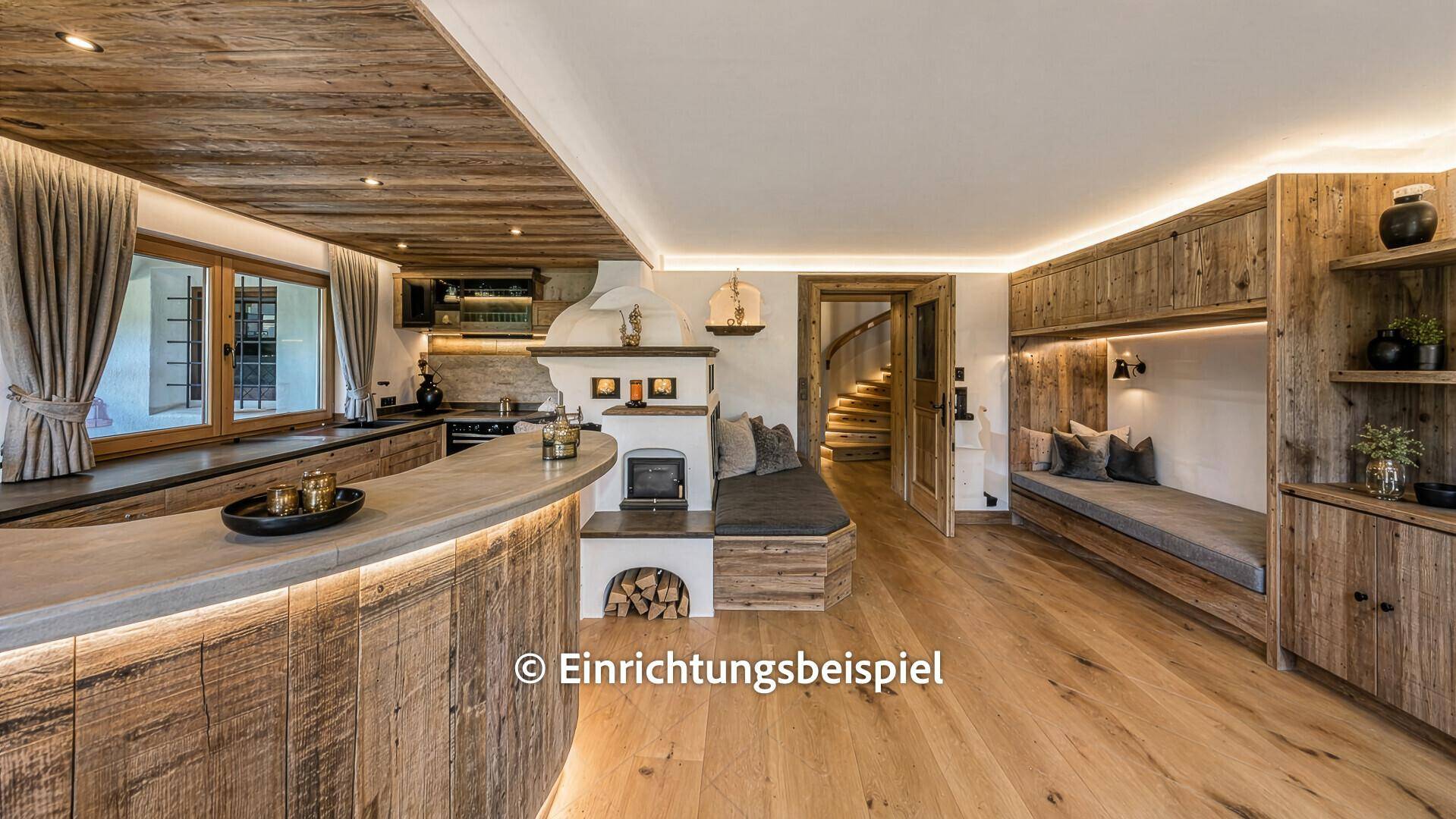 Modernisierter Wohnbereich mit Kachelofen, Bar und integrierter Küche mit Holzboden.