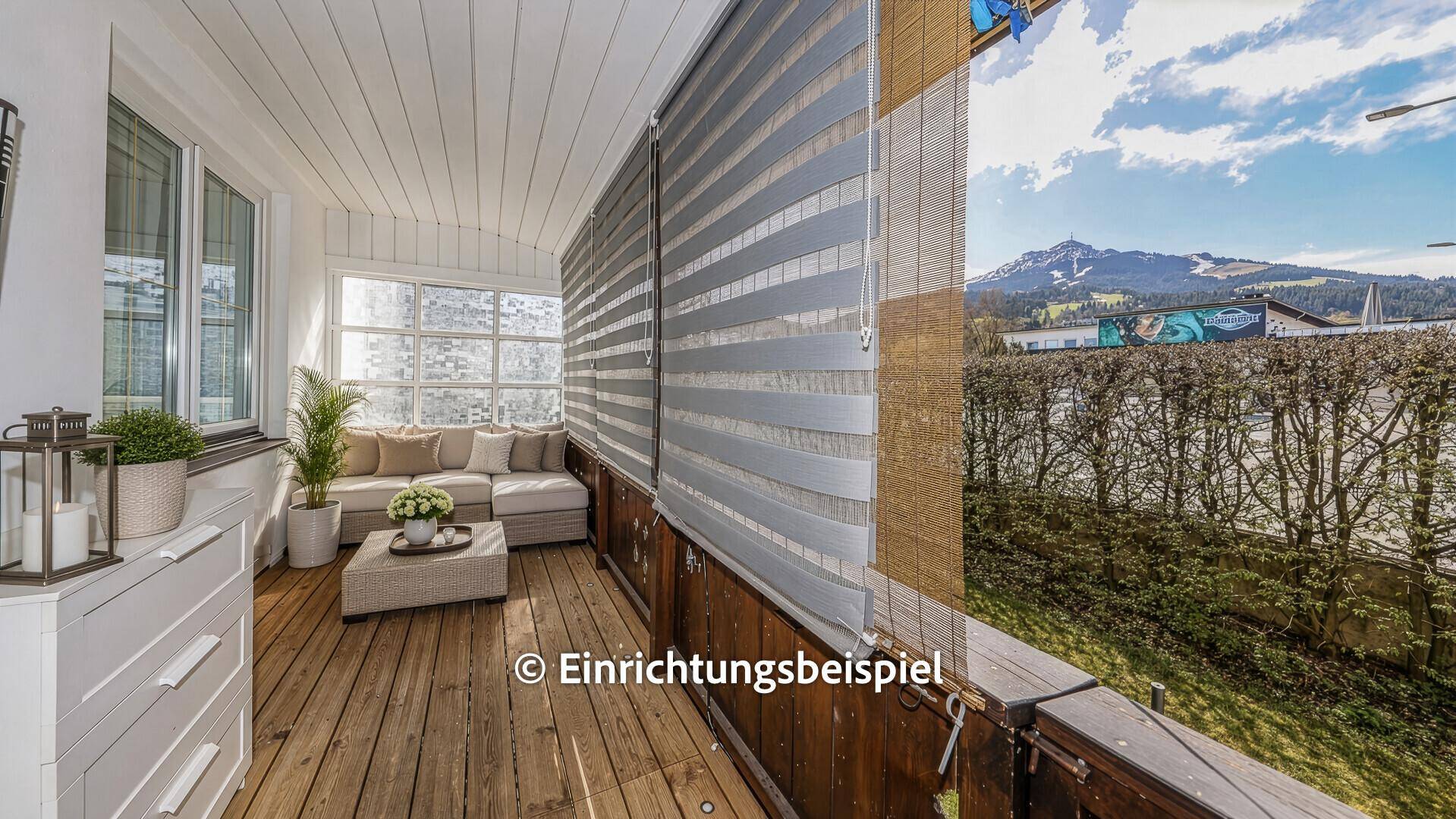 Gemütlicher verglaster Balkon mit modernen Möbeln und Bergblick, als Einrichtungsbeispiel.