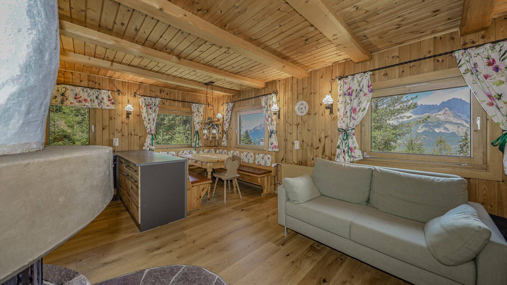 Gemütlicher Wohn-Essbereich im alpinen Stil mit Holzvertäfelung, Holzboden und traditionellen Möbeln.