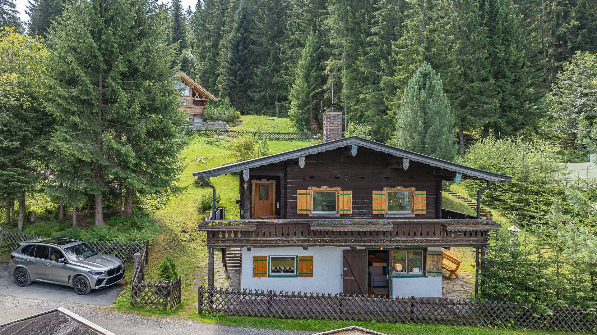 Vorderansicht des charmanten Holzchalets mit traditionellen Fensterläden und einem einladenden Balkon.