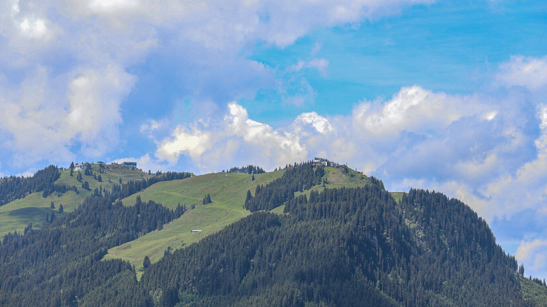 Weitläufiger Blick auf die majestätische Berglandschaft unter blauem Himmel.