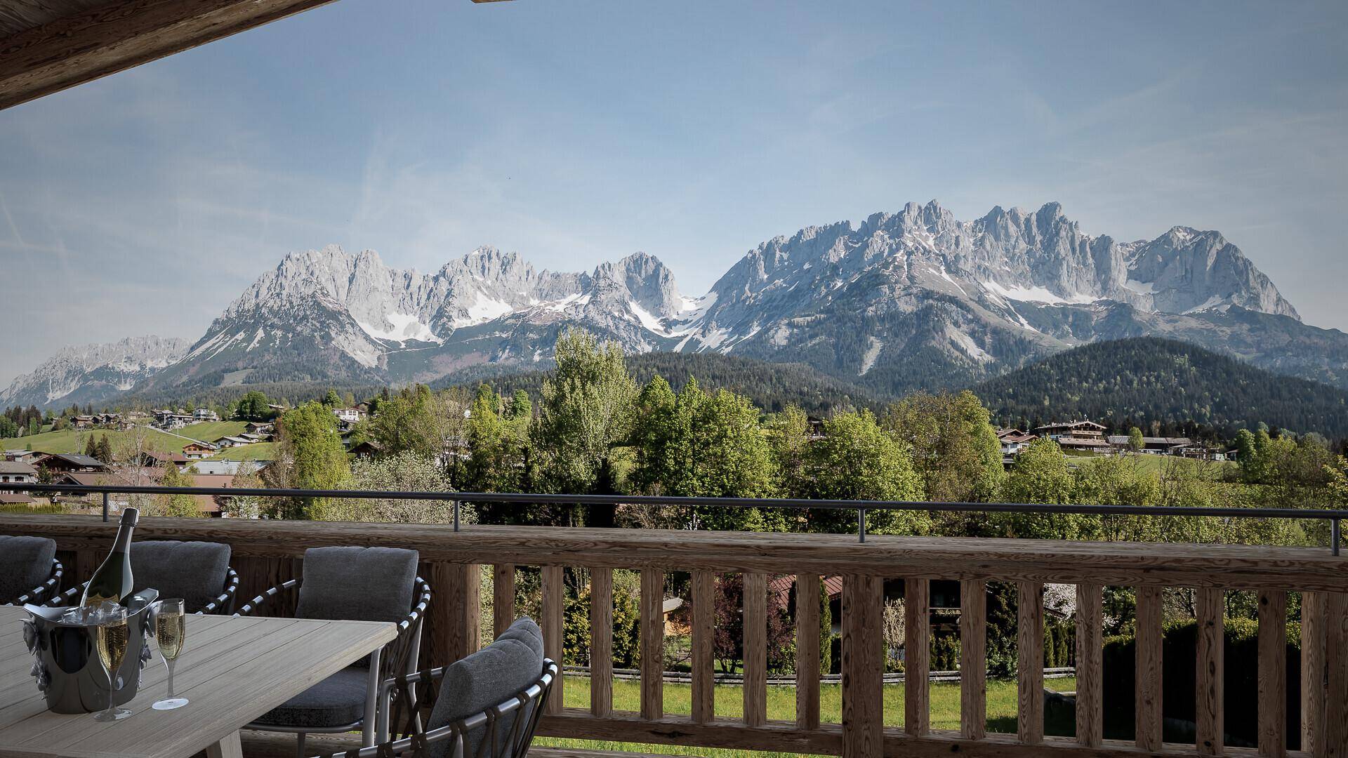 Großer Balkon mit Esstisch und Stühlen, bietet einen spektakulären Blick auf die Berge.