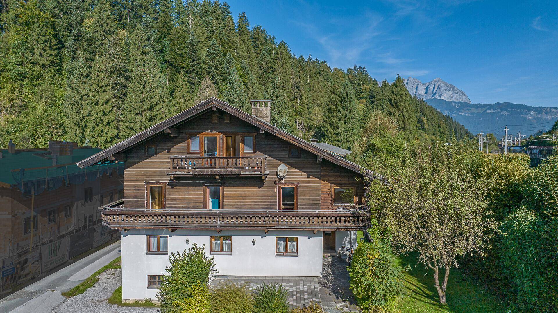 Nahaufnahme des traditionellen Holzhauses mit Holzbalkonen und Blick auf die umliegende Natur.