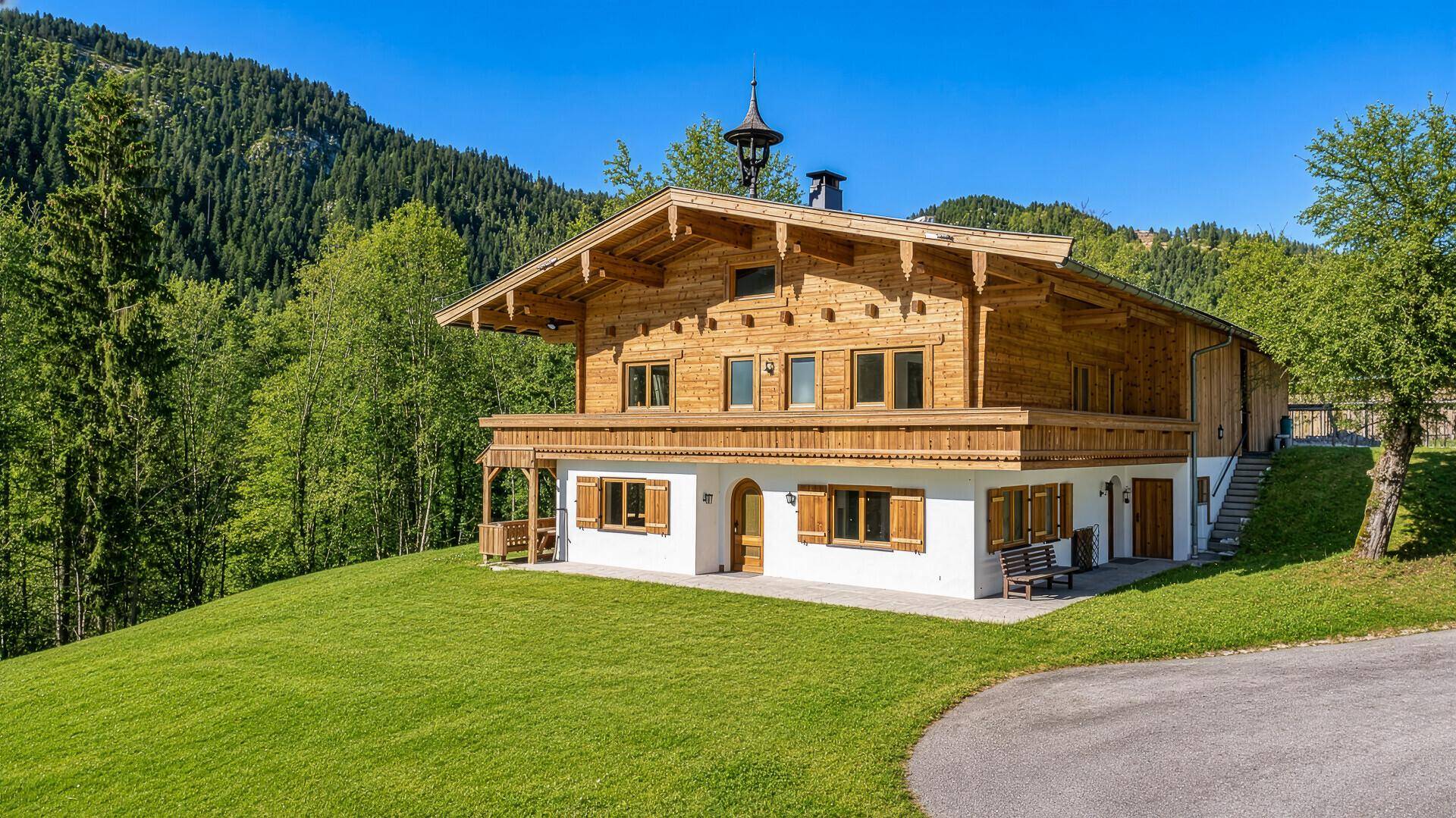 Charmantes Holzhaus im Grünen mit traditioneller Architektur und Bergblick.