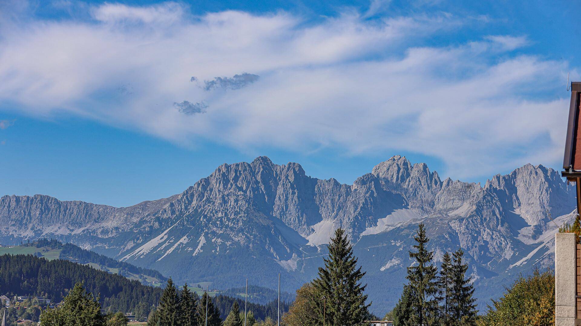 Panoramablick auf die majestätischen Berge und die umliegende grüne Landschaft.