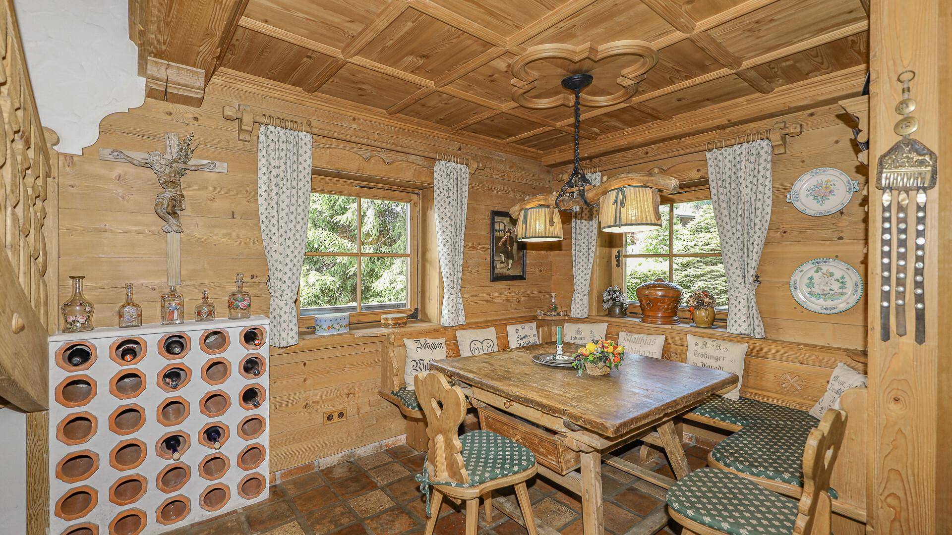 Gemütlicher rustikaler Essbereich mit Holztäfelung, Eckbank und traditionellen Möbeln.