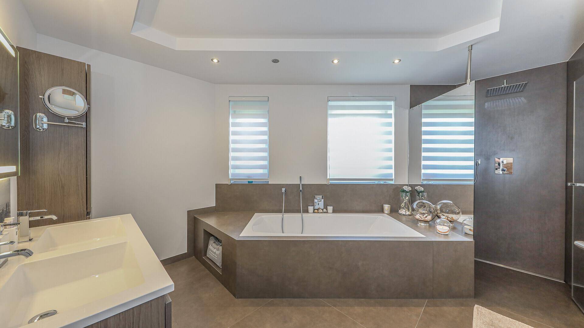 Elegantes Badezimmer mit großer Badewanne, Doppelwaschbecken und moderner begehbarer Dusche.