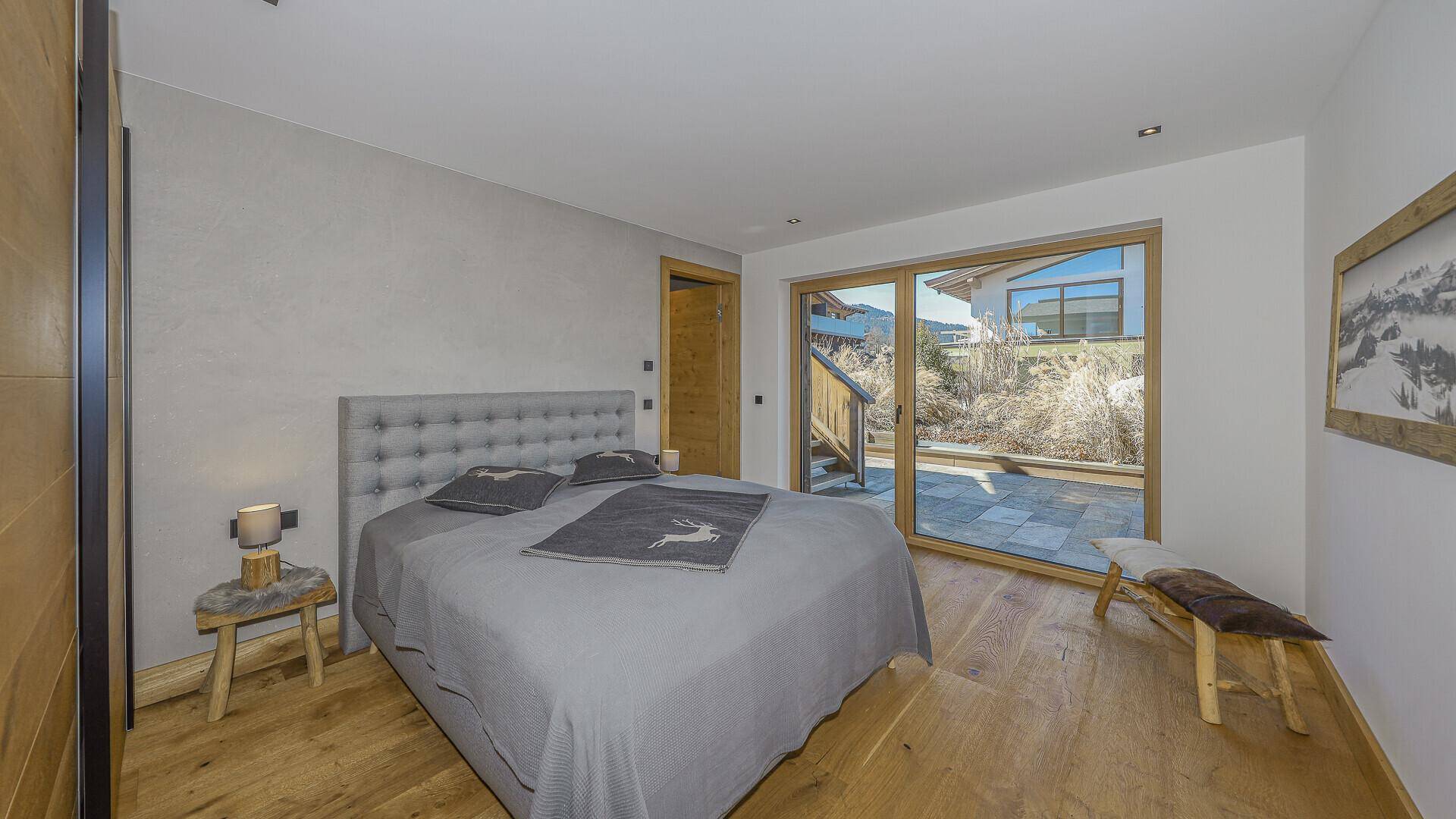 Helles Schlafzimmer mit Zugang zu einer Terrasse und modernem Interieur.