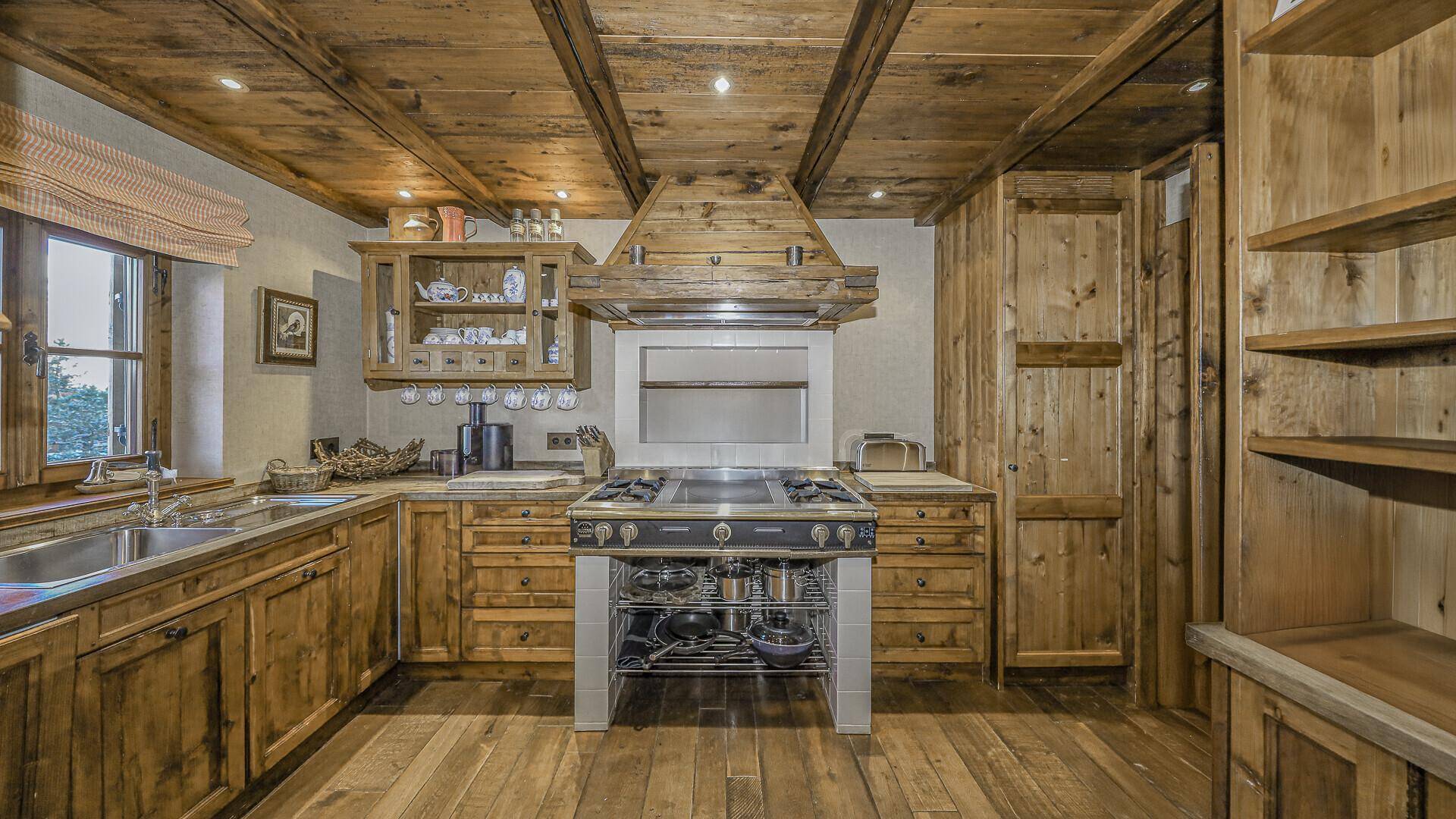 Rustikale Holzküche mit traditionellem Herd, Holzbalkendecke und viel Stauraum.