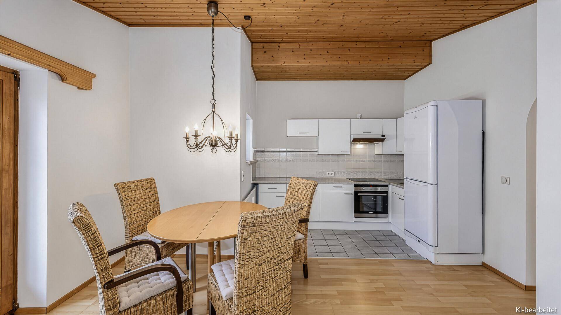 Gemütlicher Essbereich mit Holzbalkendecke und kleiner Küchenzeile, ideal für Mahlzeiten.