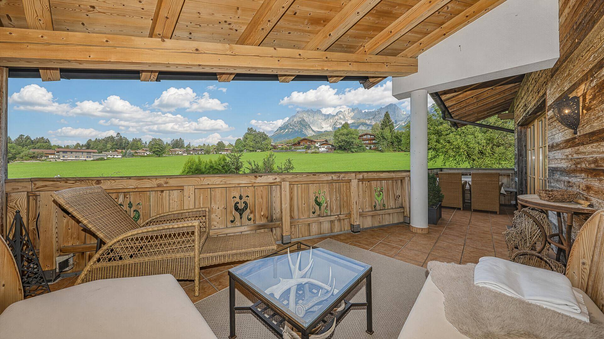 Geräumiger Balkon mit Sitzgelegenheiten und atemberaubendem Blick auf die umliegende Bergwelt.