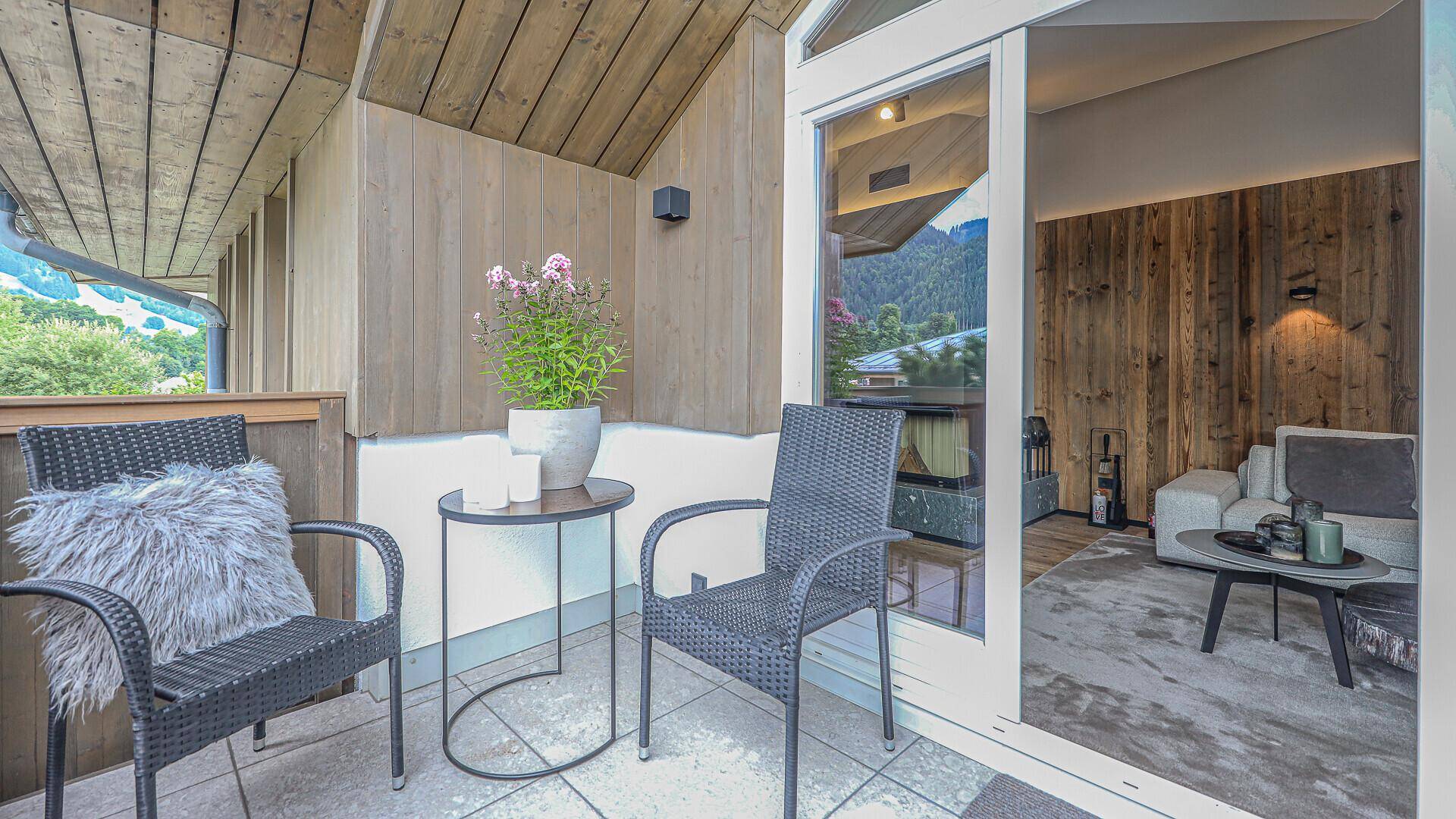 Kleiner Balkon mit Sitzgelegenheiten und Topfpflanzen, zugänglich vom Wohnbereich.
