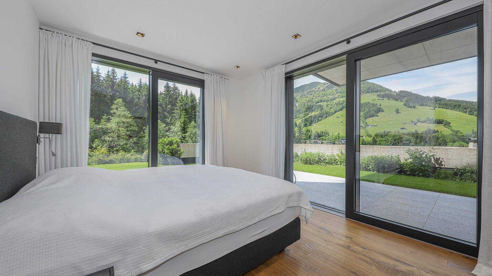 Helles Schlafzimmer im Erdgeschoss mit direktem Zugang zum Garten und Blick ins Grüne.