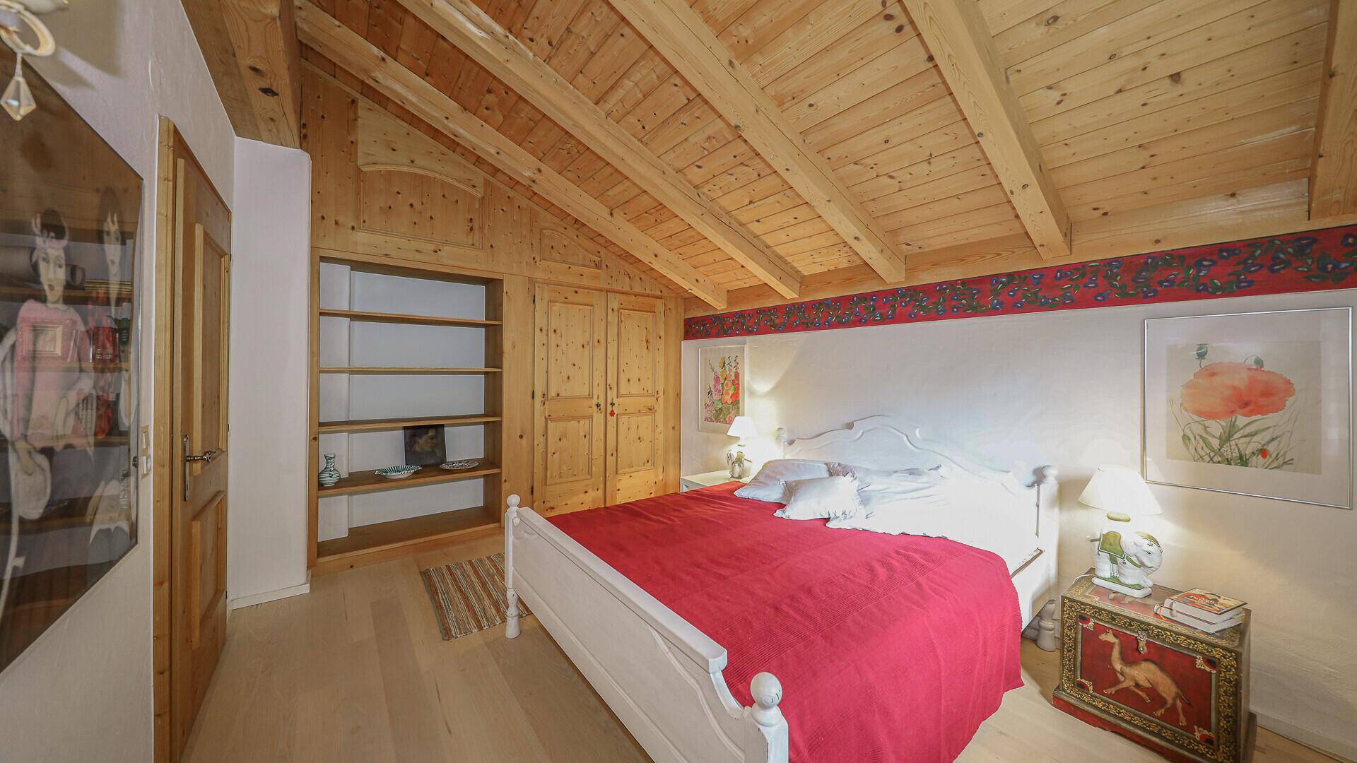 Gemütliches Schlafzimmer mit Holzbalkendecke, Einbauschränken und rustikalem Charme.