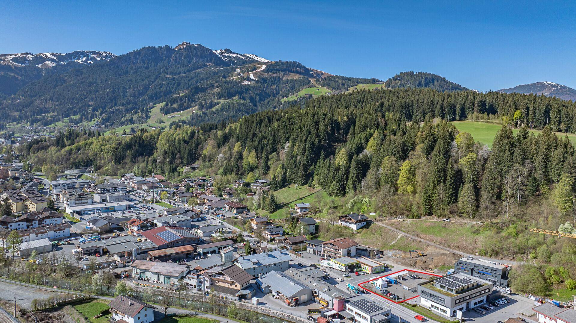 Panoramische Luftaufnahme einer Bergregion mit einem Dorf und dem hervorgehobenen Grundstück.