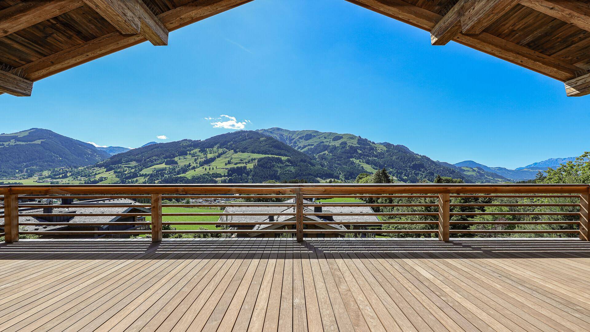 Geräumige Holzterrasse mit Holzbalkon und atemberaubendem Panoramablick auf die umliegende Bergwelt.