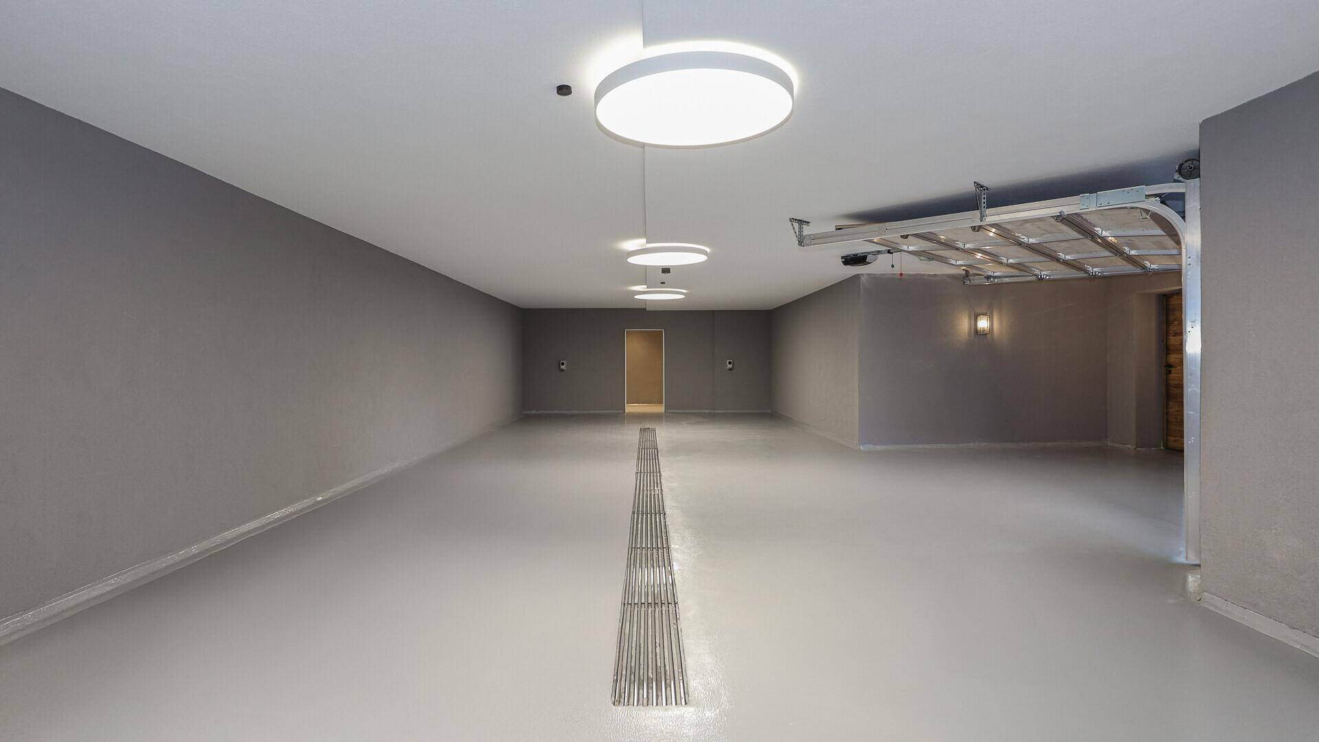 Geräumige Tiefgarage mit glattem Boden und modernen Deckenleuchten.