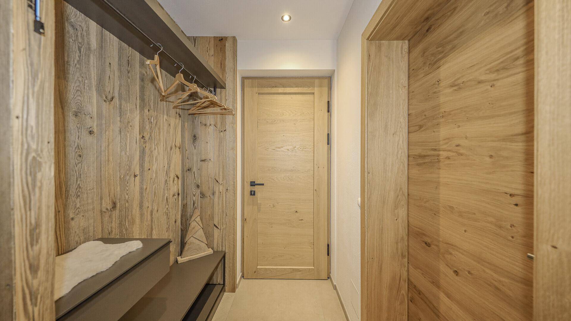 Heller Flur mit Holzwänden und Garderobenbereich, der einen einladenden Eingang schafft.