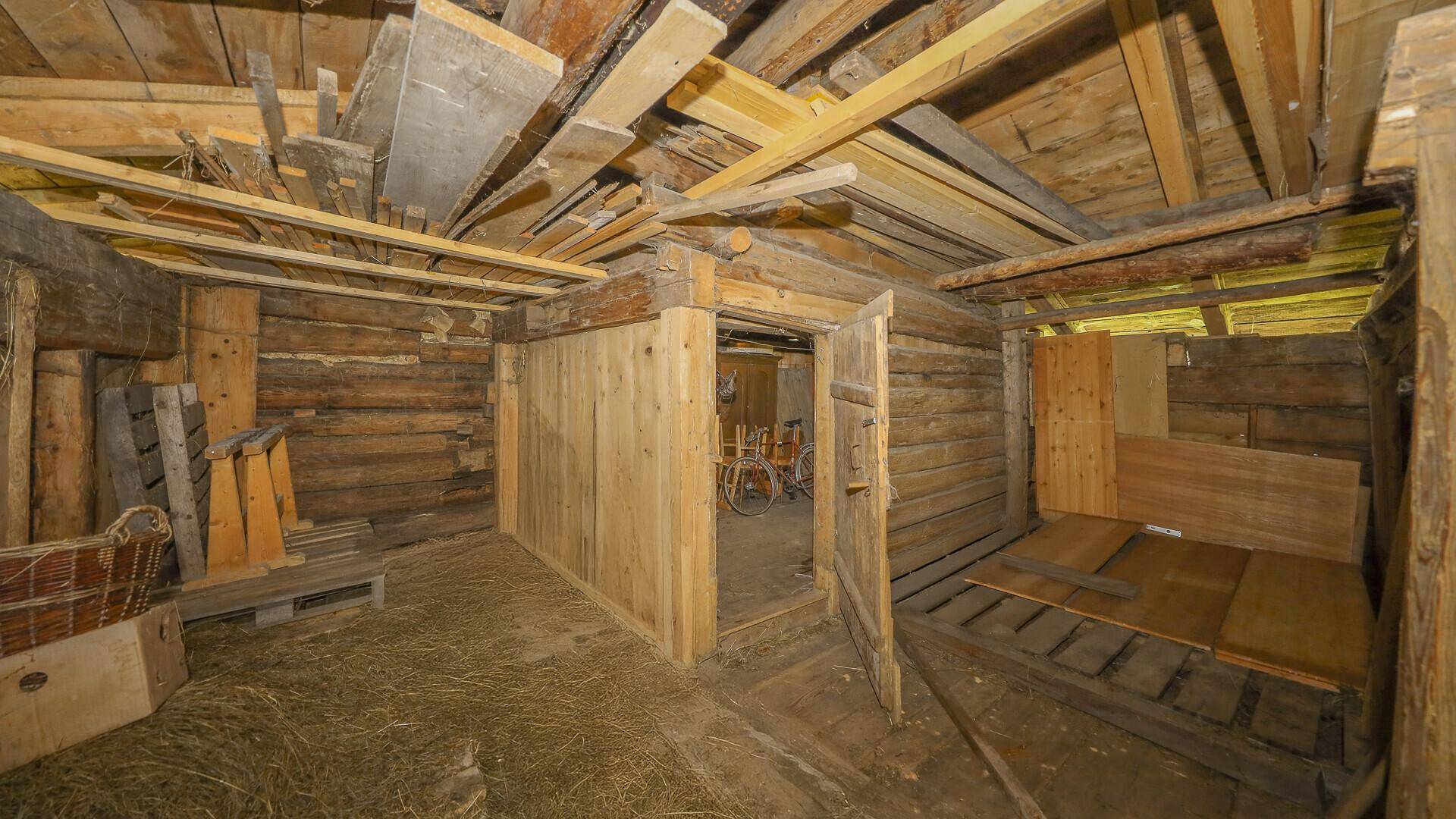 Rustikaler Dachboden mit Holzbalken und unfertigen Wänden, ideal für Ausbauprojekte.