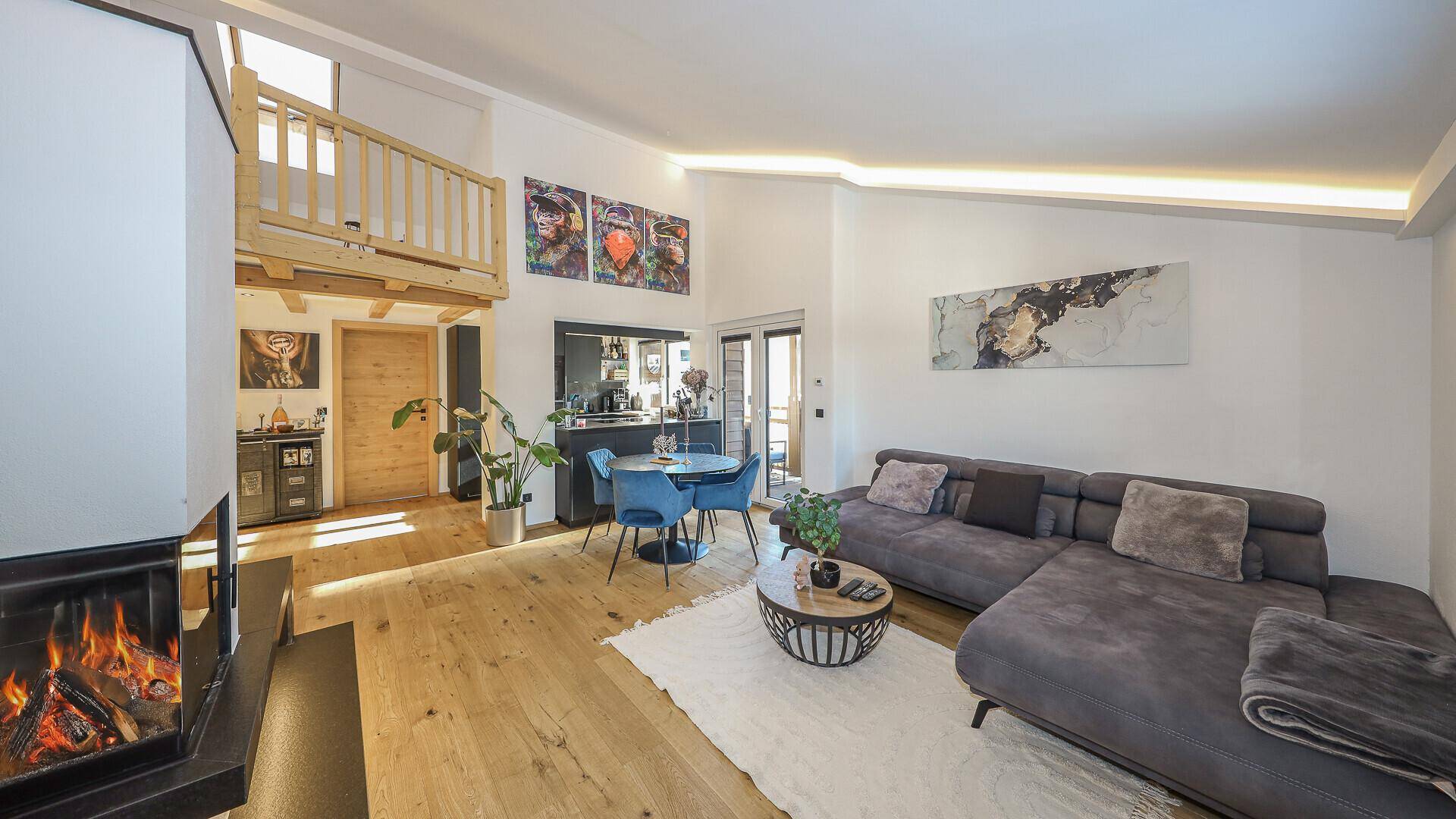 Gemütlicher Wohnbereich mit Kamin, Holzboden und Zugang zu einem Hochbett.