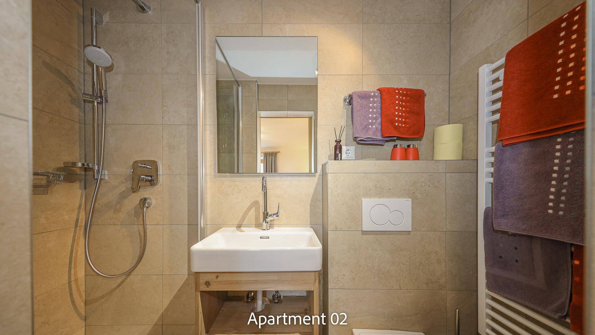 Modernes Badezimmer mit Dusche, Waschbecken und beheiztem Handtuchhalter.
