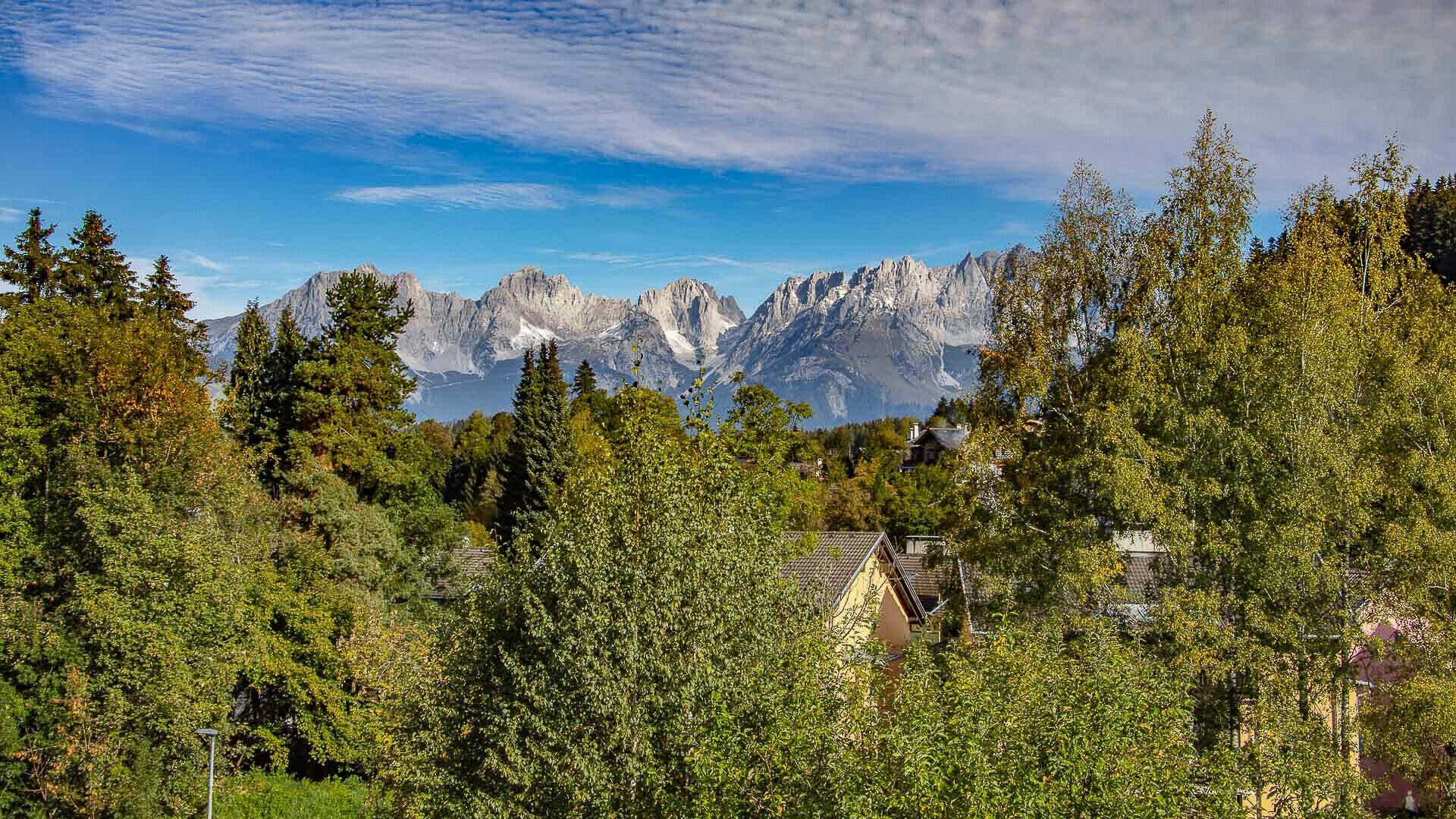 Panoramablick auf die majestätische Bergkette, umgeben von üppigen grünen Bäumen.