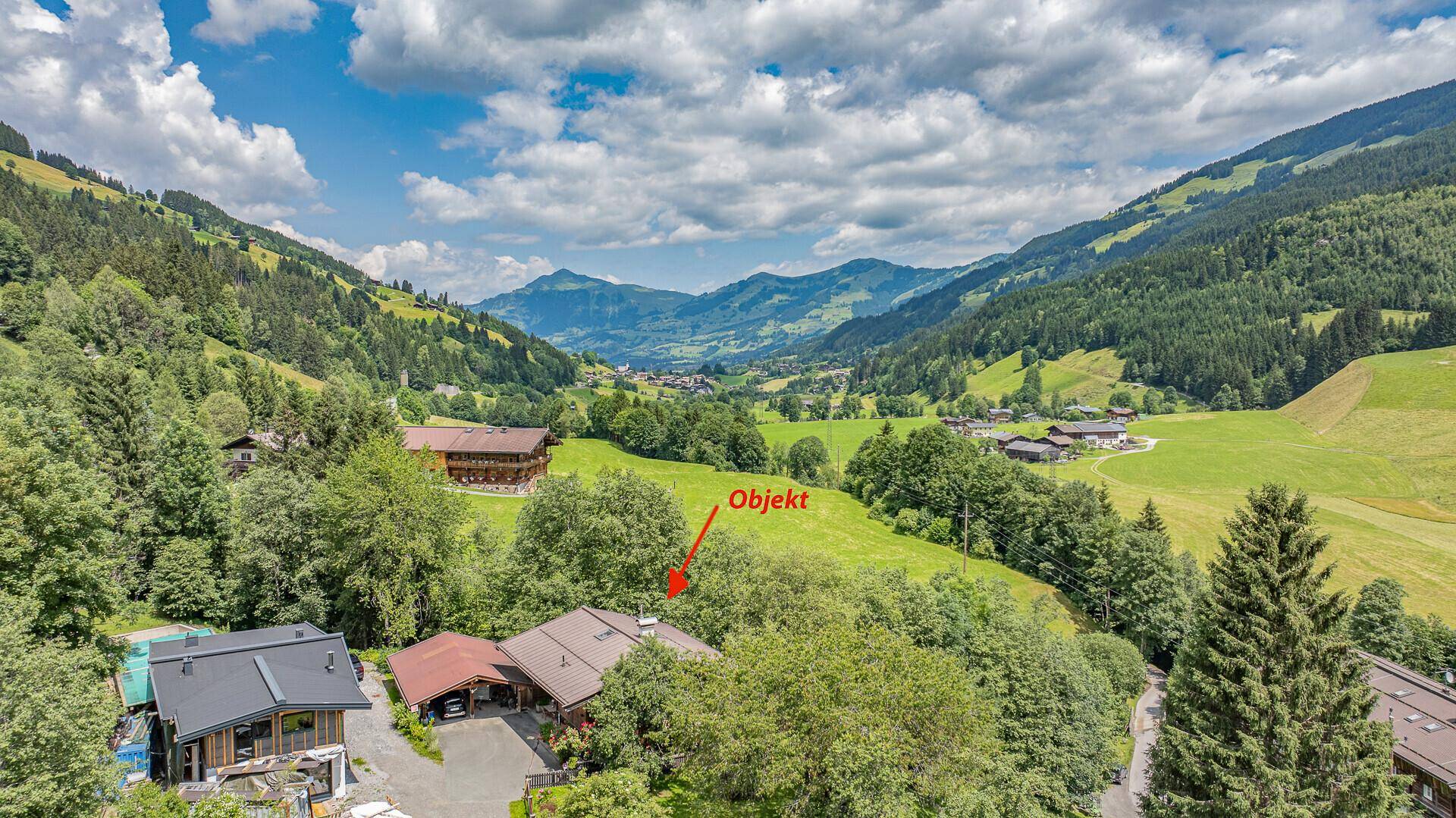 Luftaufnahme des Anwesens in einer malerischen Berglandschaft mit umliegenden Wäldern und Tälern.