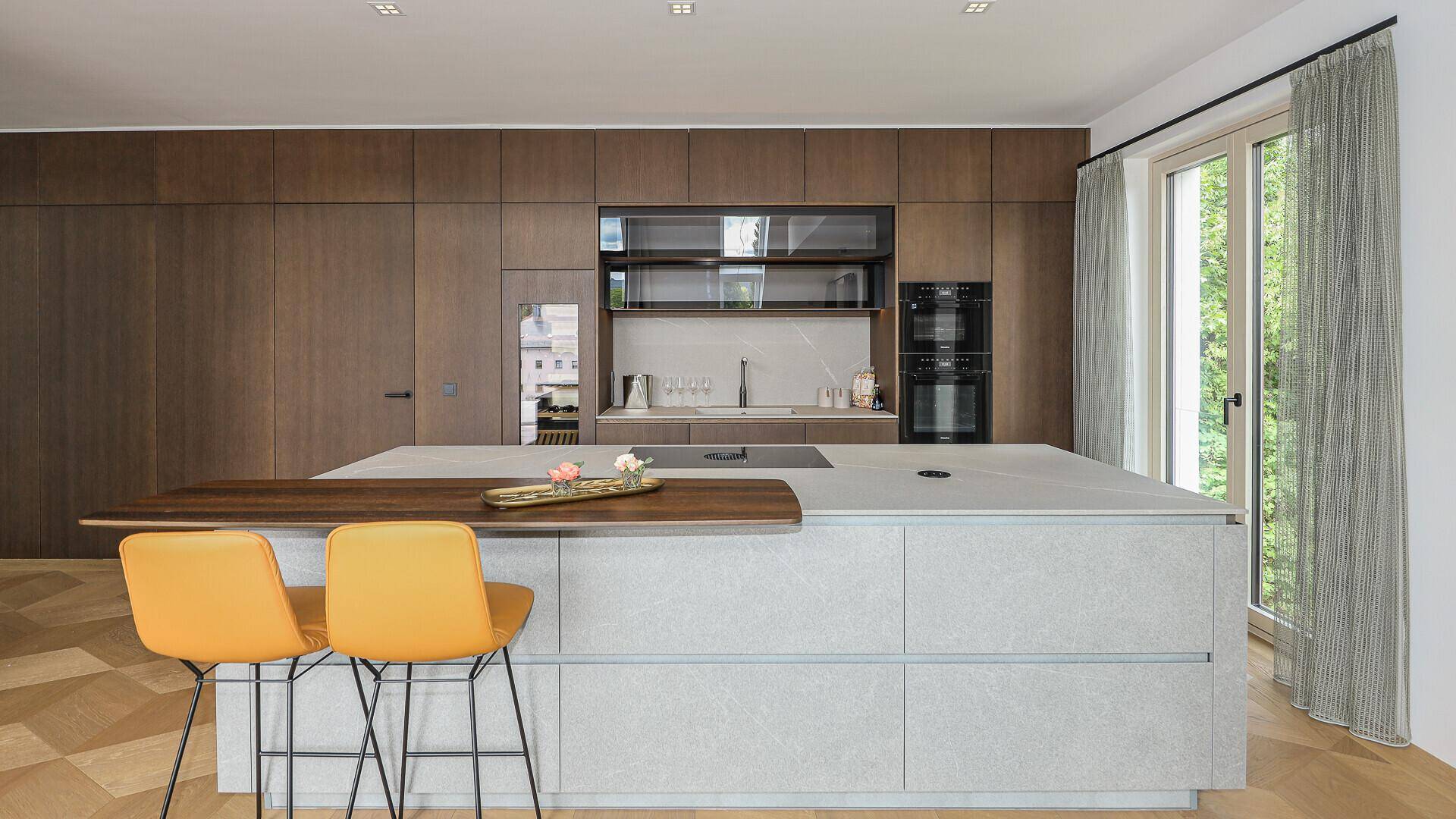 Moderne Einbauküche mit hochwertigen Geräten, Kücheninsel und Holzakzenten.
