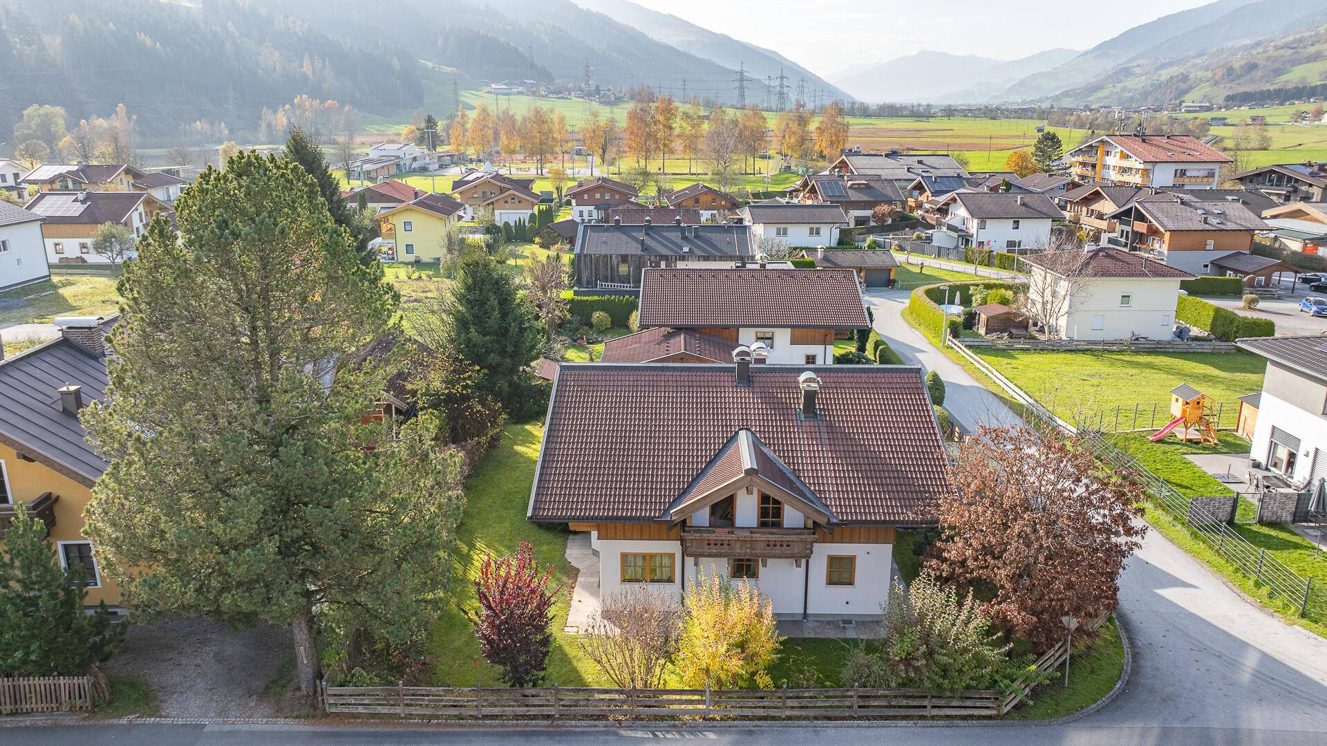 Luftaufnahme des Hauses mit umliegenden Gärten und der malerischen Berglandschaft im Hintergrund.