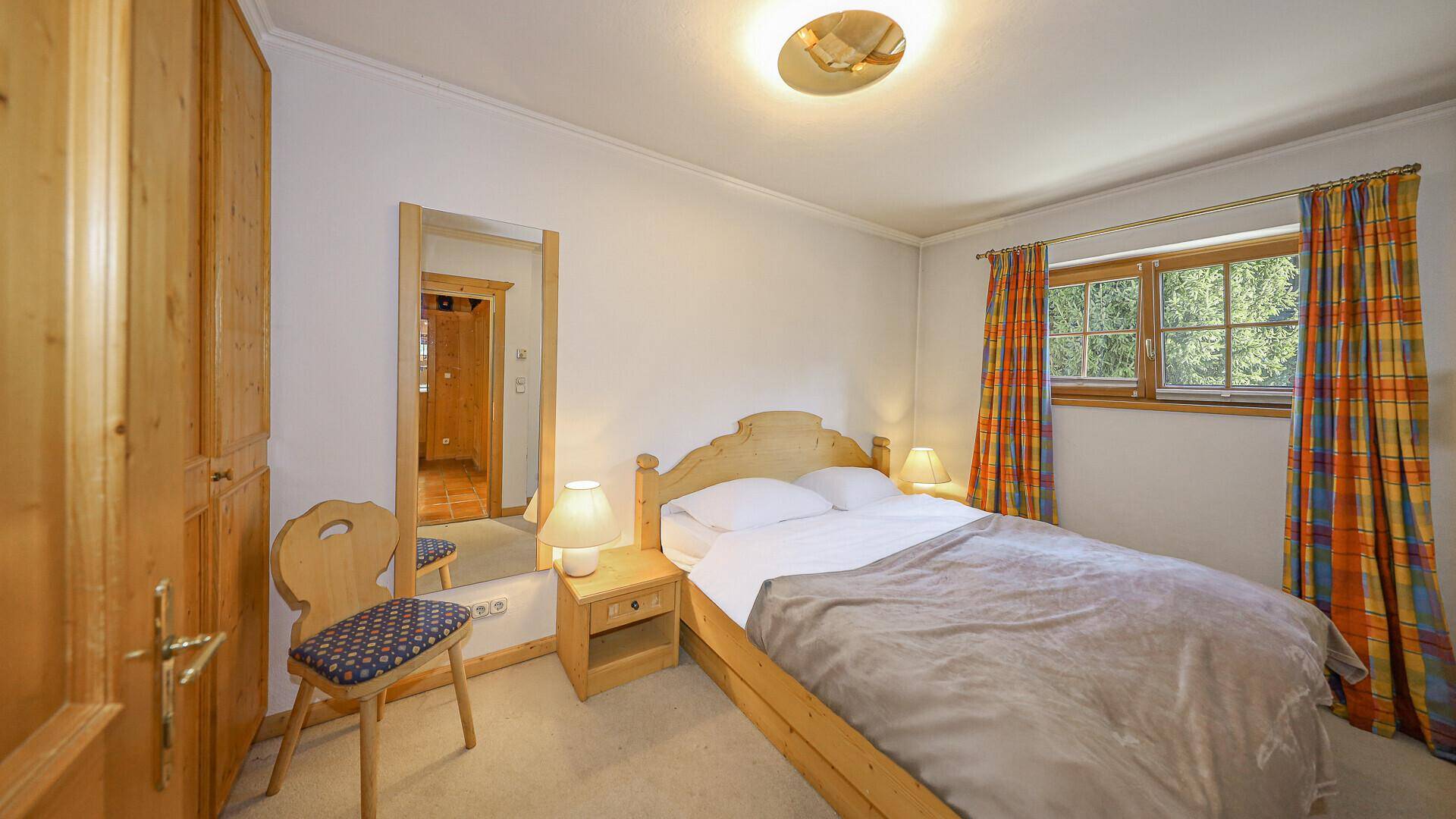 Gemütliches Schlafzimmer mit Einzelbett, Teppichboden und traditioneller Einrichtung.